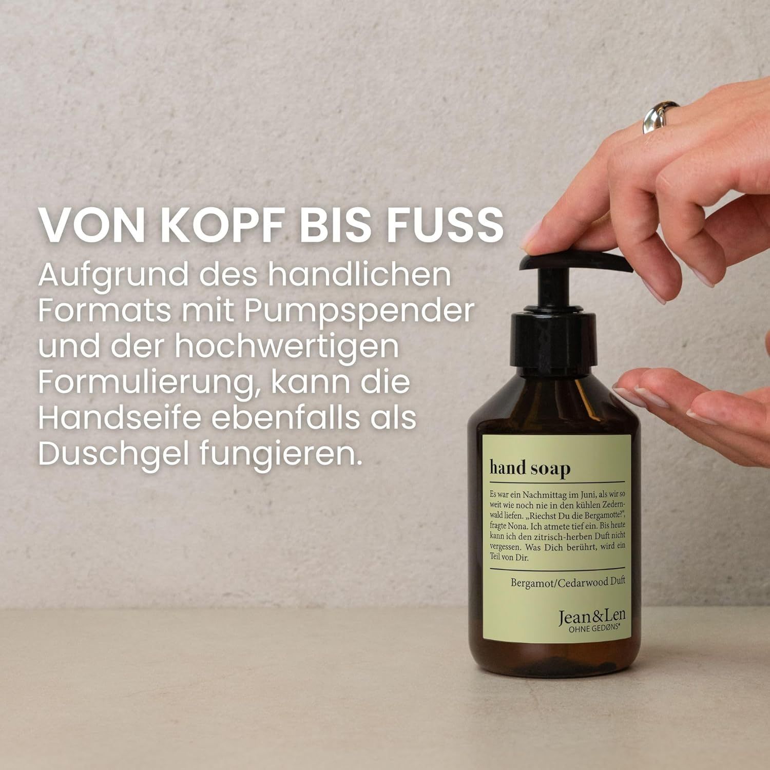Flacon brun avec pompe noire. Inscription : hand soap, parfum Bergamot/Cedarwood. Logo Jean & Len. Main touchant le distributeur.