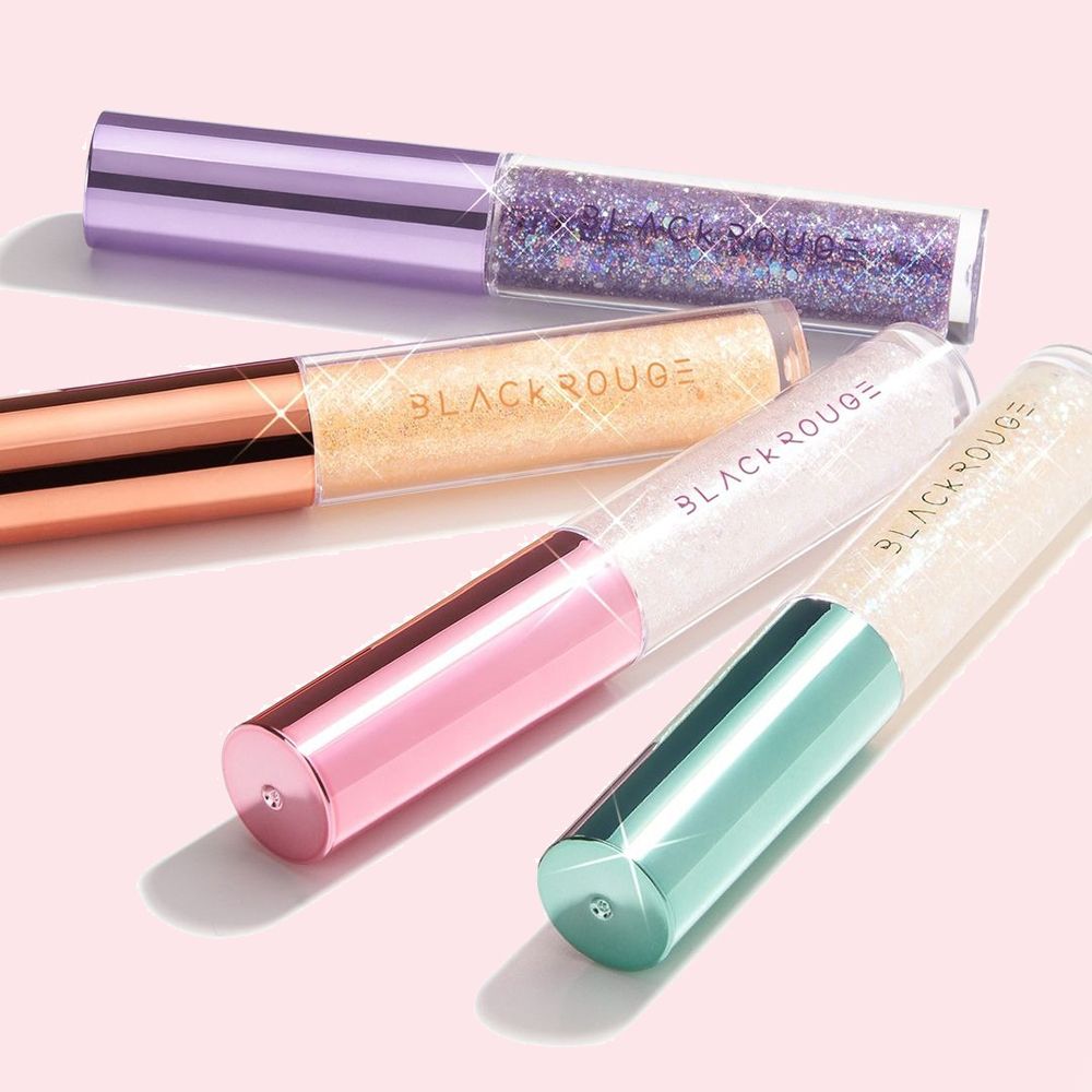 Quatre tubes de fard à paupières pailleté avec des bouchons colorés. Les textes "BLACK ROUGE" sont visibles sur les produits.