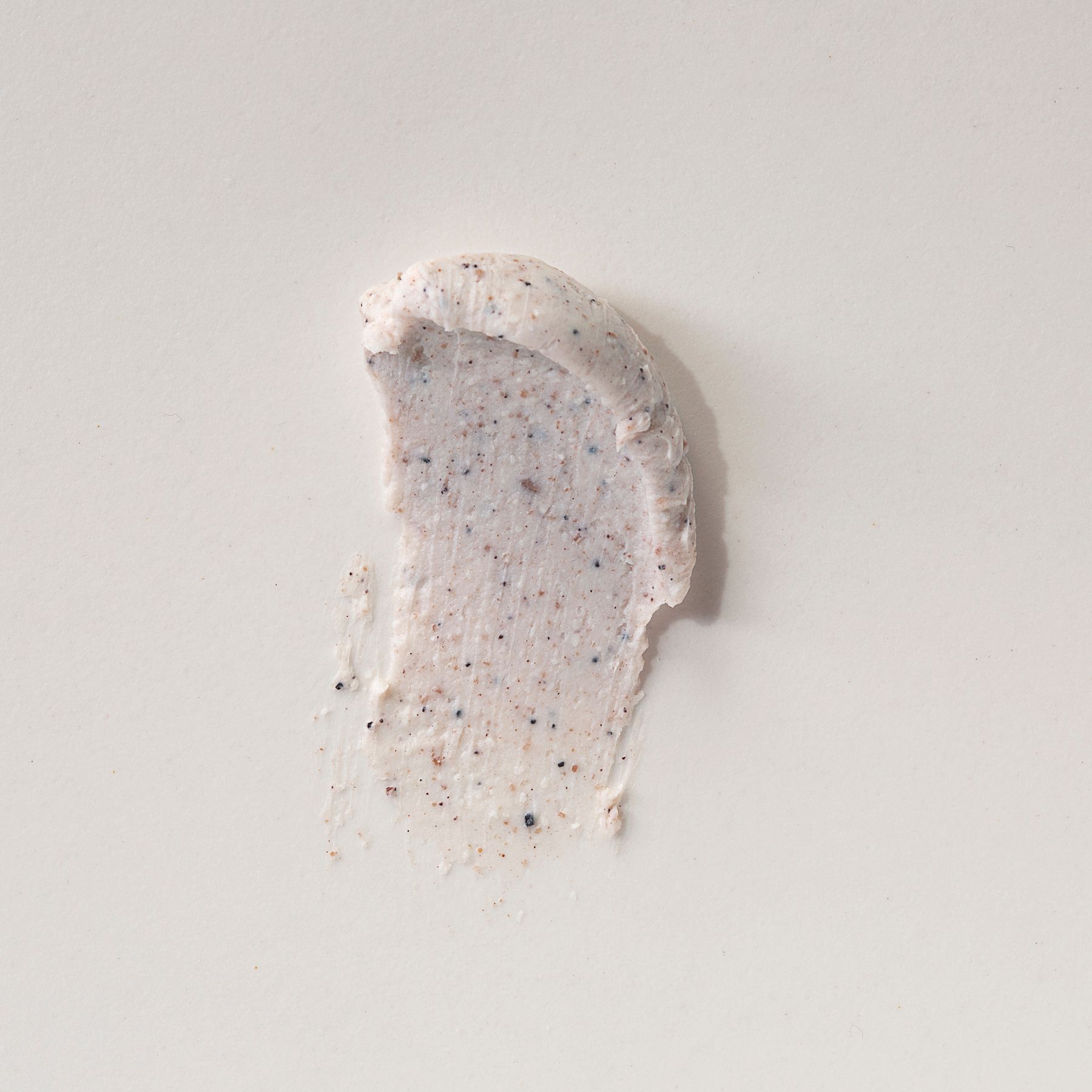 Un échantillon du gommage corps Alkemy Karité Butter Scrub sur fond clair.
