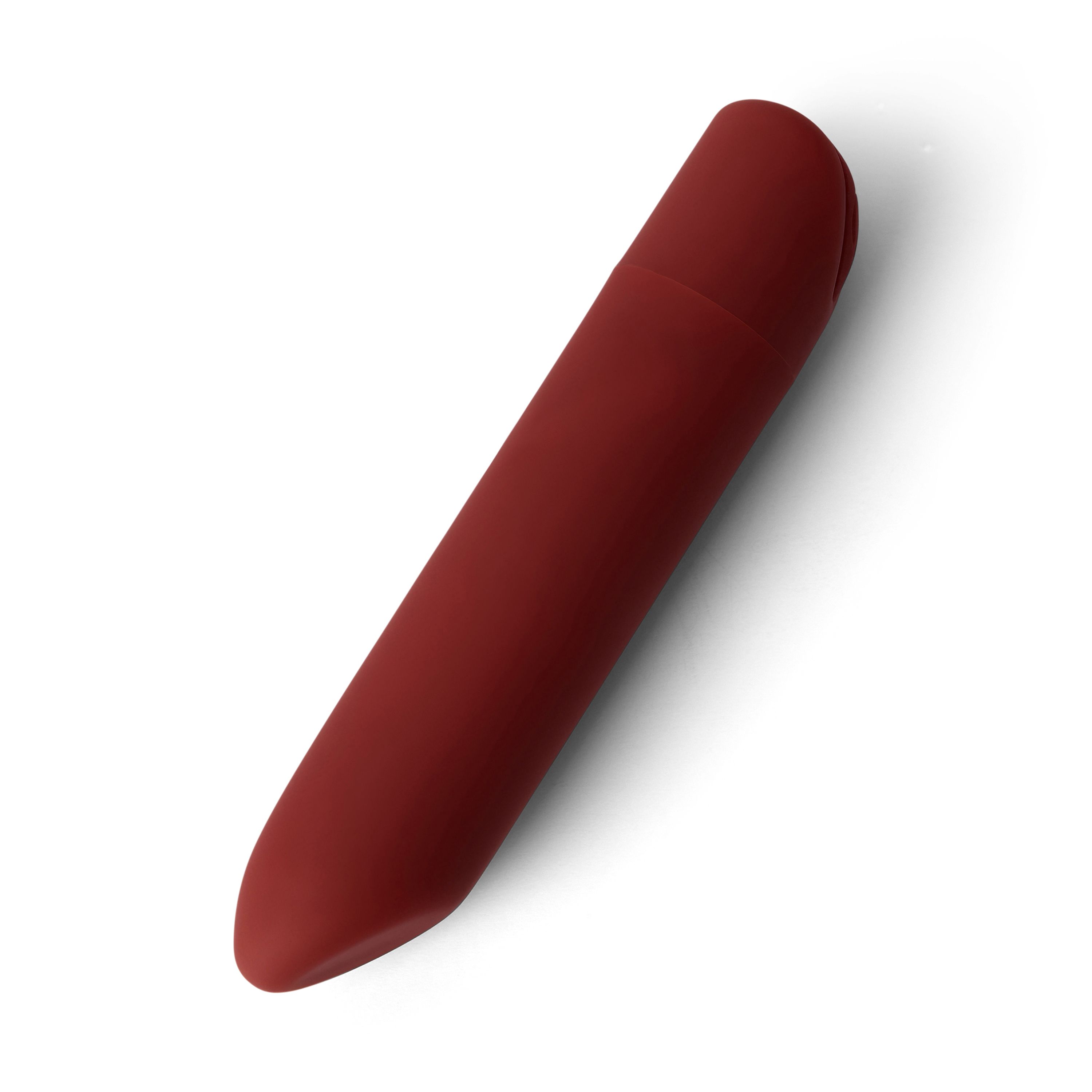 Objet allongé rouge, extrémités arrondies. Légère indentation sur le dessus. Sur fond blanc.