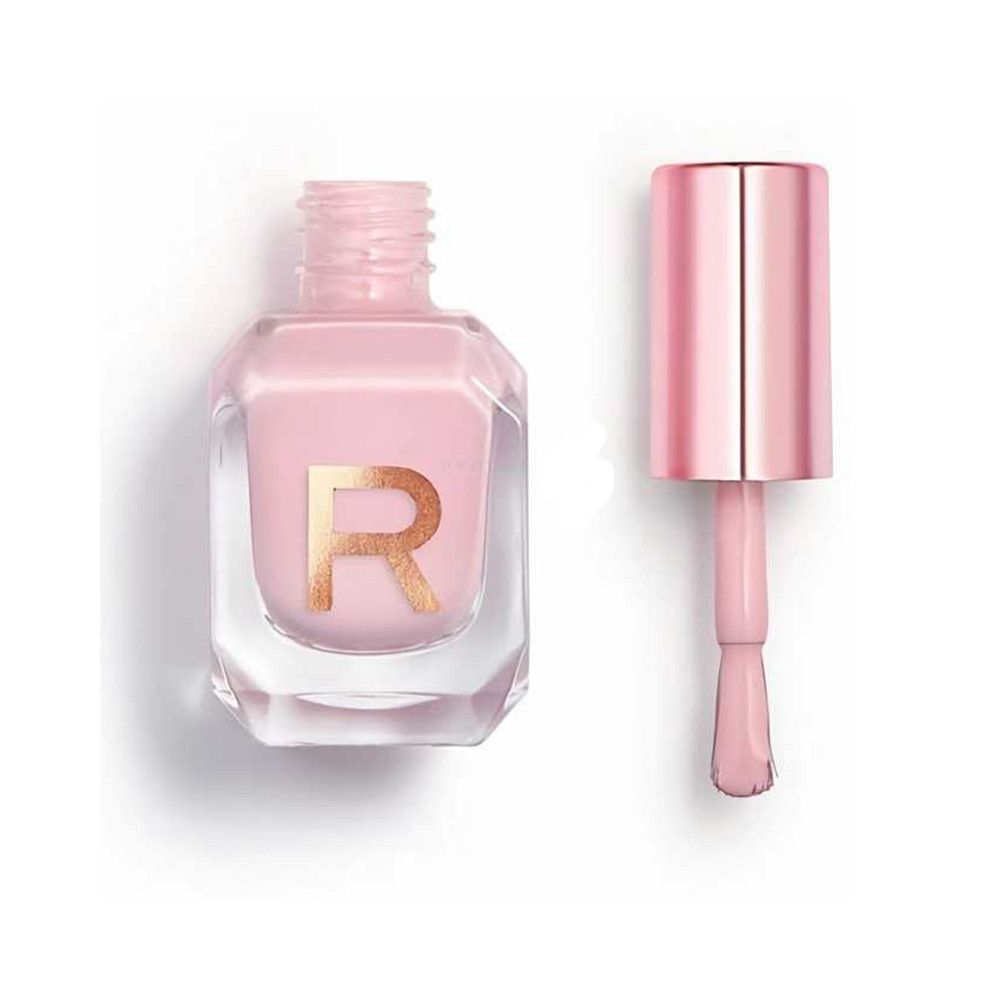 Een flesje lichtroze nagellak met een gouden 'R'-logo en een aparte kwast.