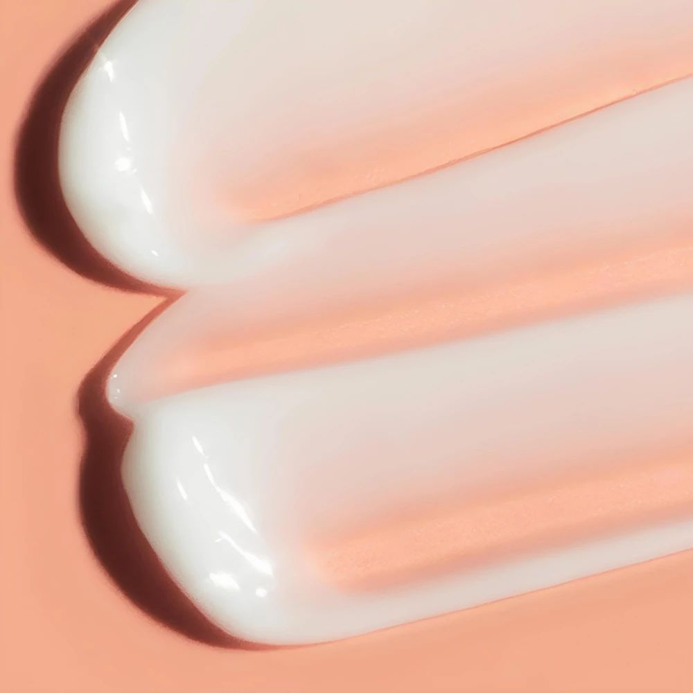 Gros plan sur deux bandes crémeuses. Texture crème sur fond rose.