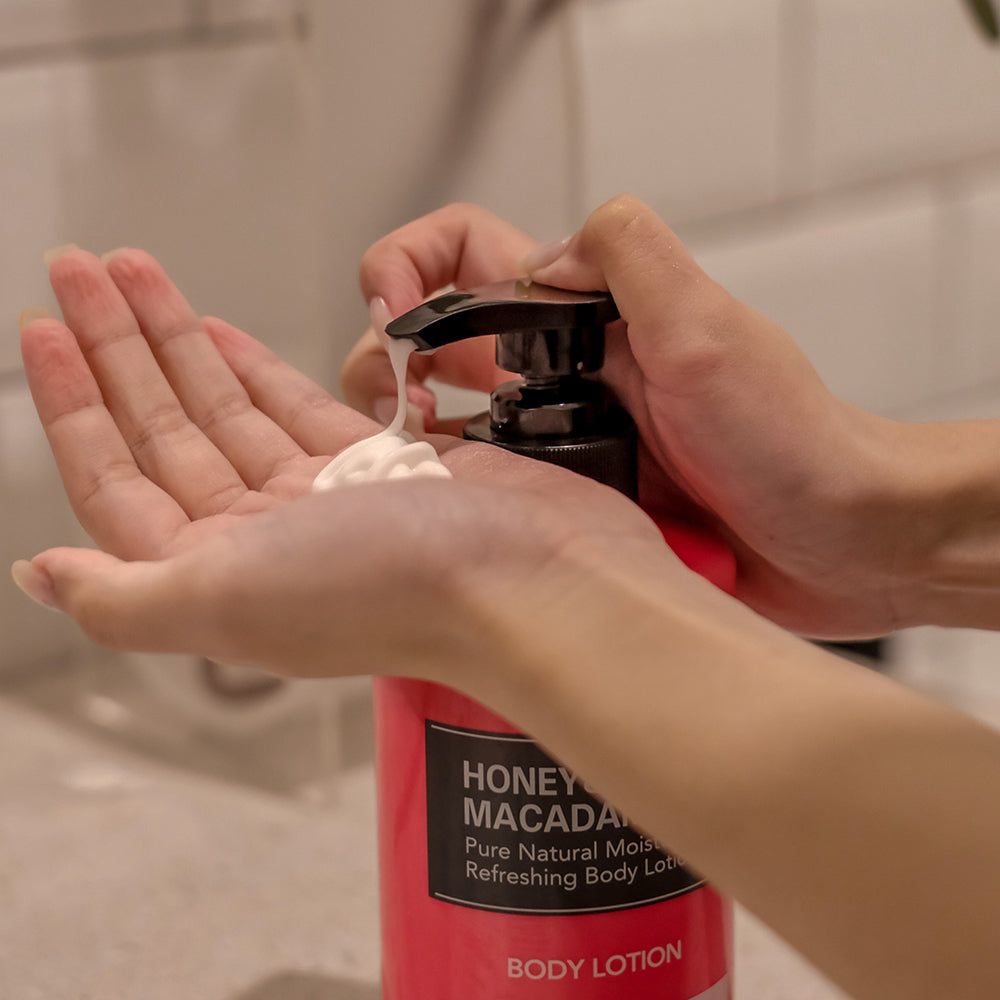 Een hand pompt Kundal bodylotion in de andere hand. Pompdispenser met lotion.