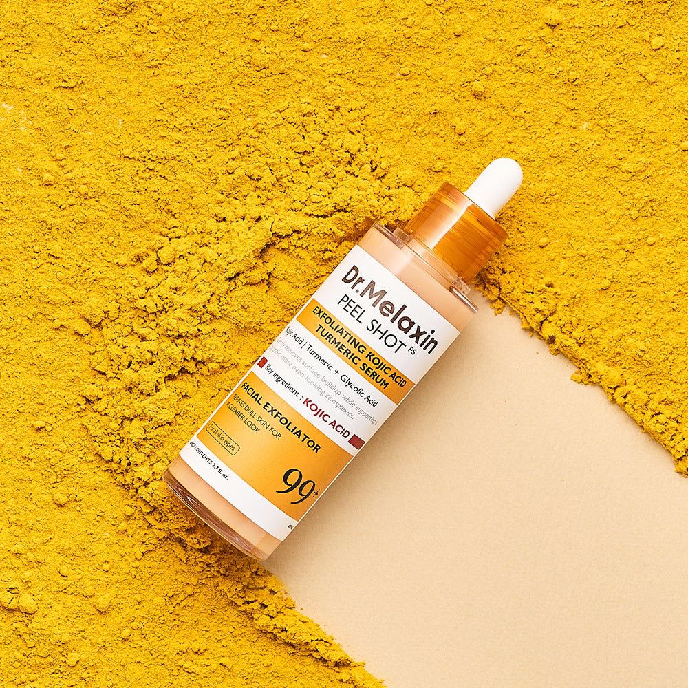 Dr. Melaxin Peel Shot serum met kojic zuur en kurkuma, omringd door kurkumapoeder.