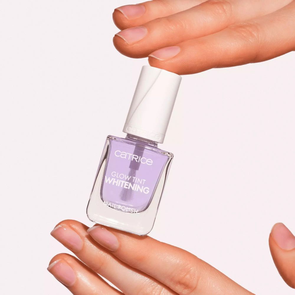 Nagellakfles in handen. Lila tint, opschrift 'Glow Tint Whitening'.