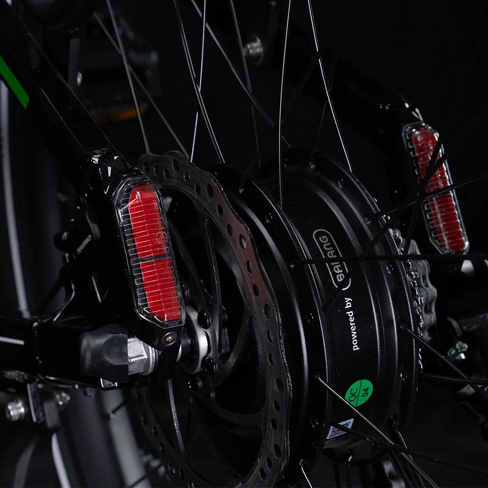Gros plan du frein arrière et du moteur. Réflecteurs rouges et frein à disque. Inscription : Powered by Bafang.
