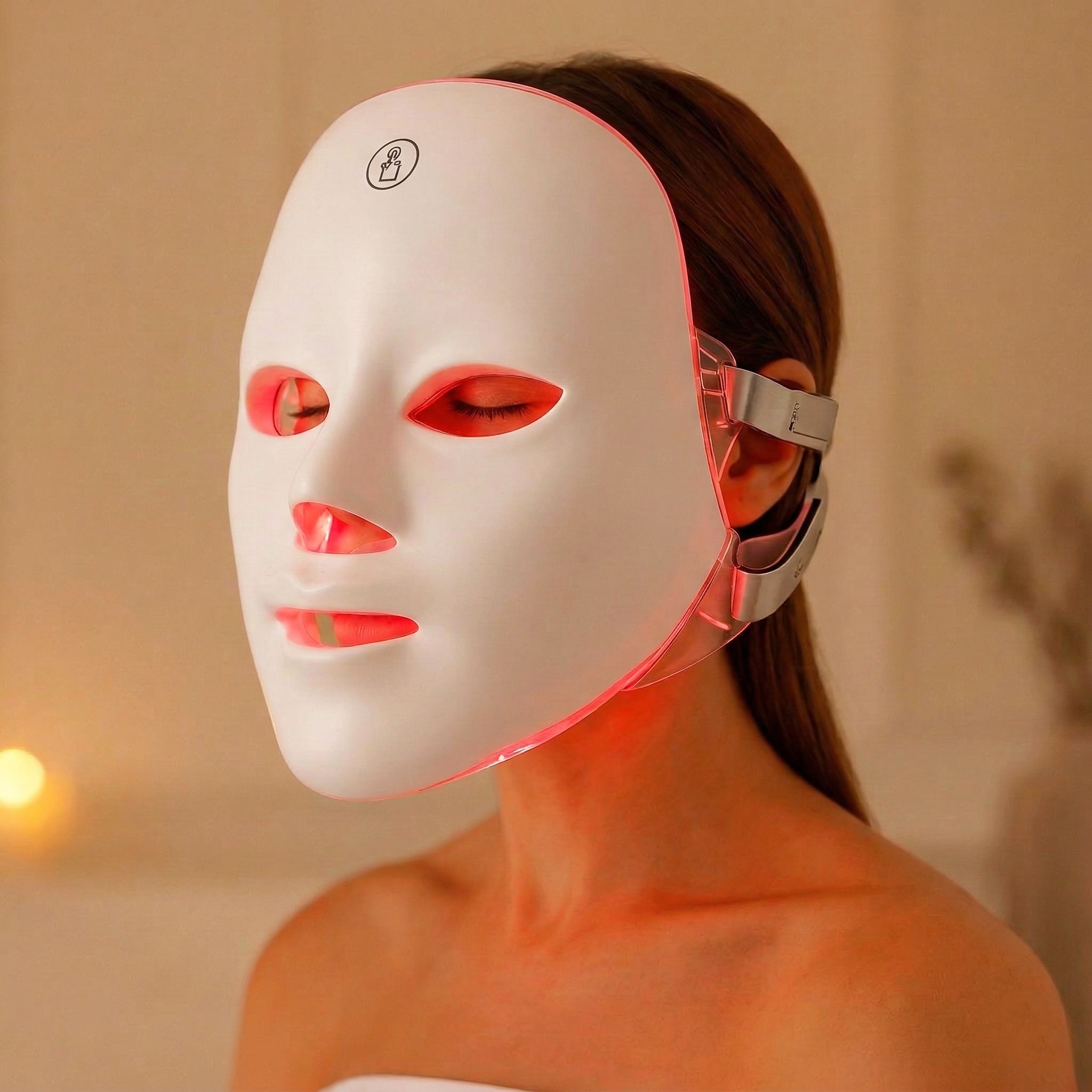 Wit gezichtsmasker met rode lichten, gedragen door een persoon. Zijaansluitingen zijn zichtbaar.