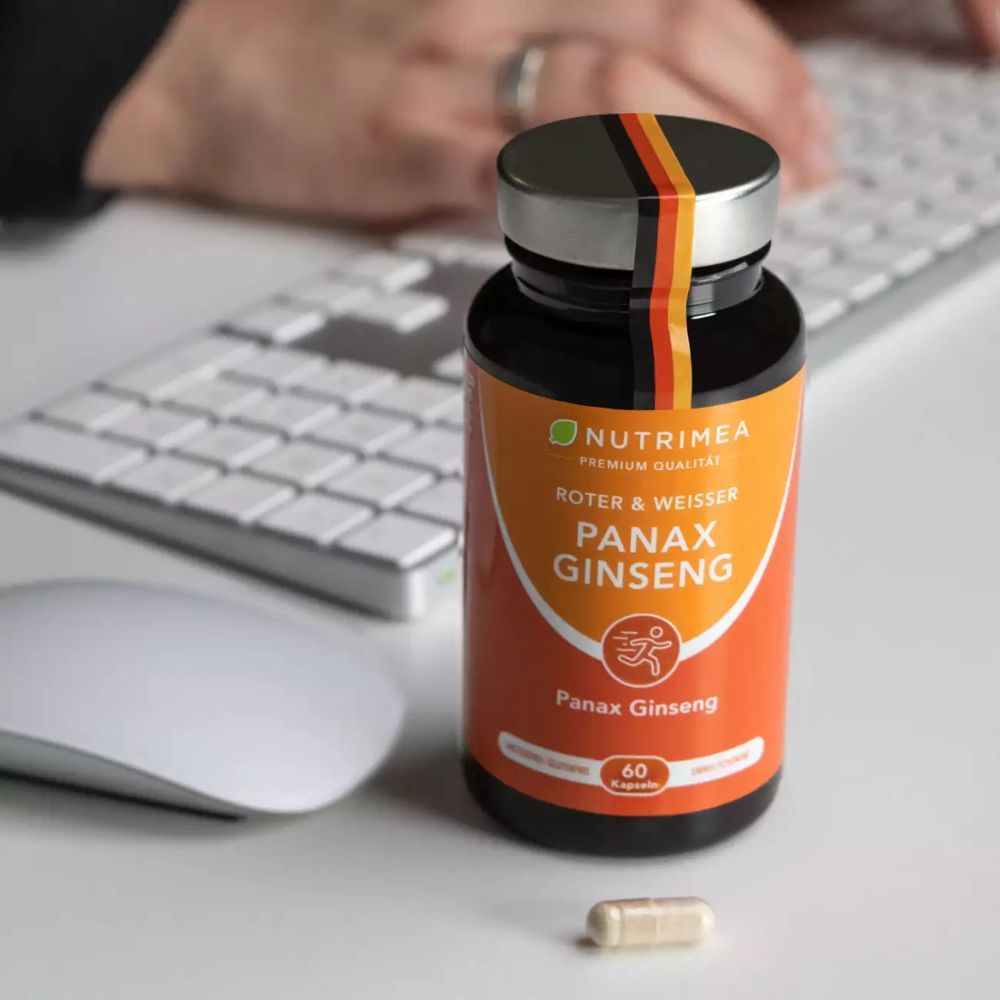 Flacon Nutrimea PANAX GINSENG sur un bureau. Une gélule à côté. Clavier et souris en arrière-plan.