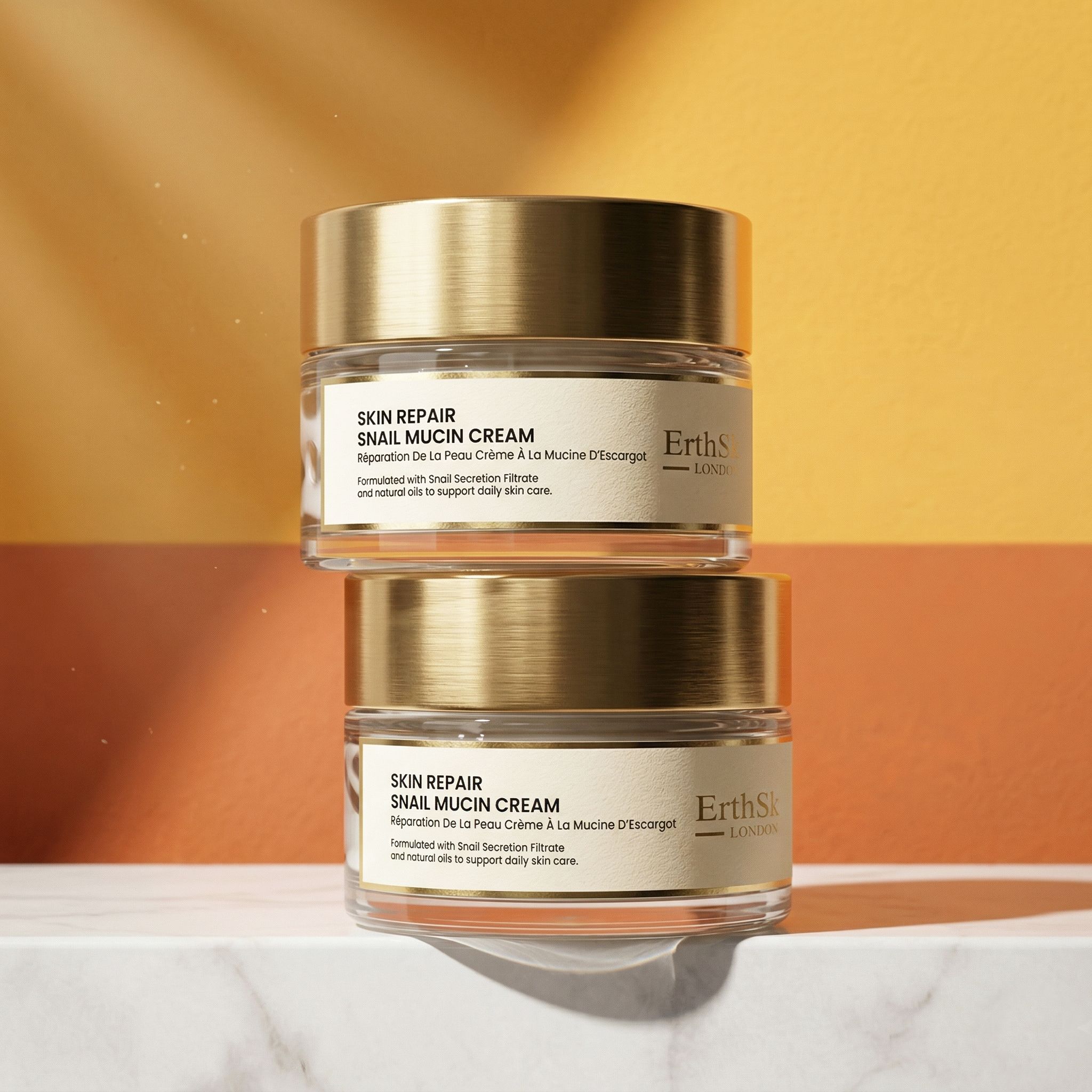 Twee glazen potten met gouden deksels. Opschrift: Skin Repair Snail Mucin Cream. Merk: ErthSkin London.