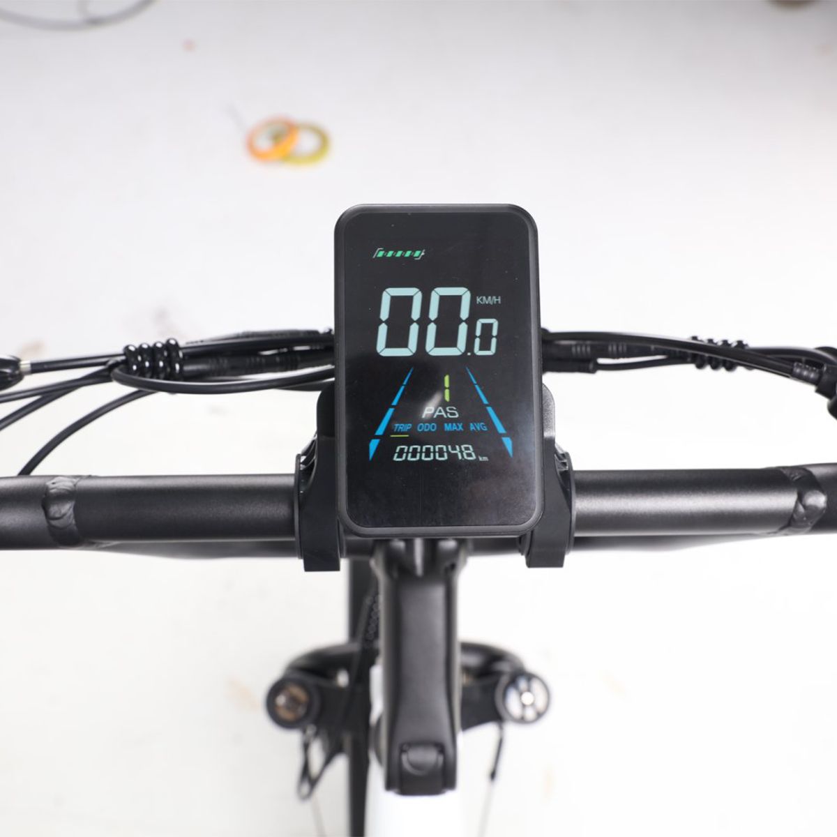 Écran numérique affichant la vitesse, l'état de la batterie et d'autres informations. Cadre noir.