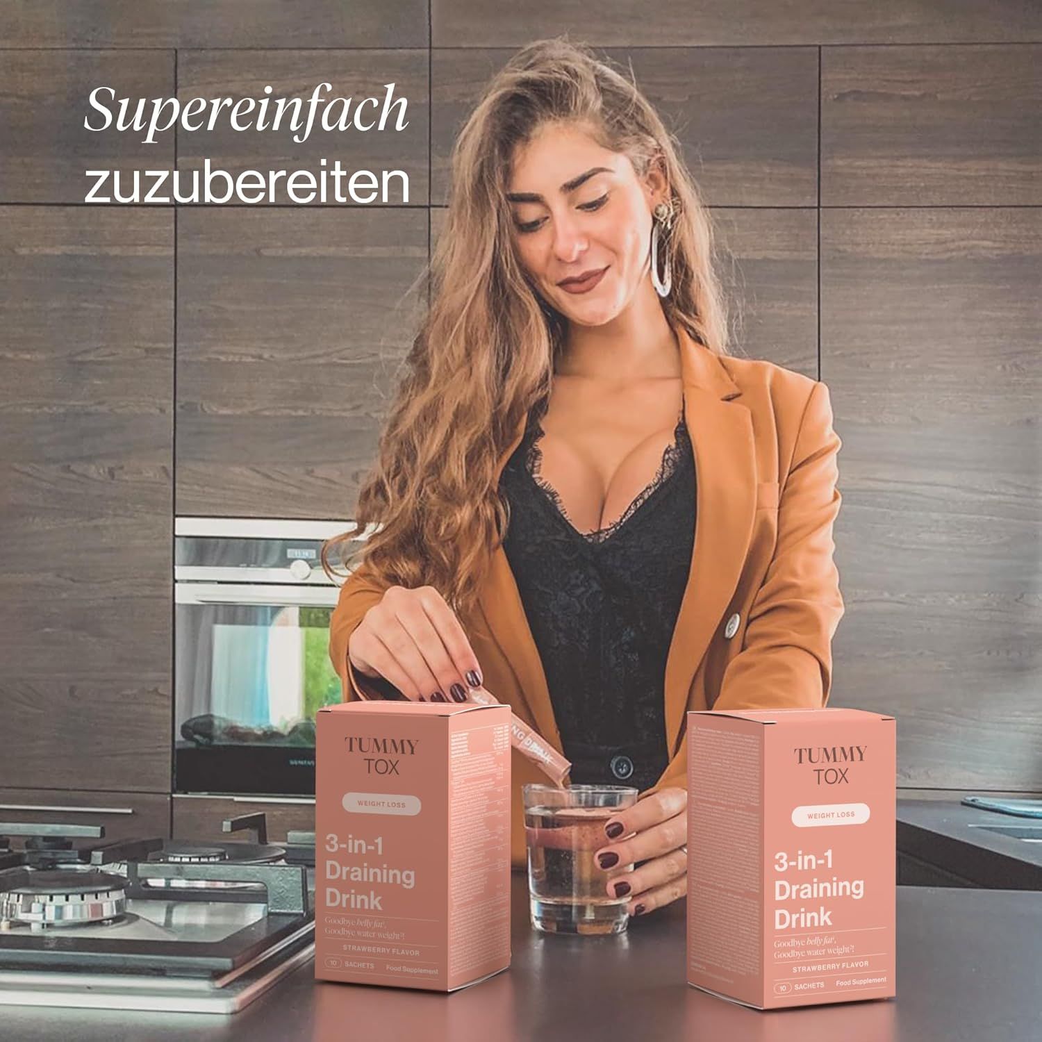 Femme dans une cuisine avec deux paquets de Tummy Tox 3-en-1 Draining Drink et un verre d'eau.