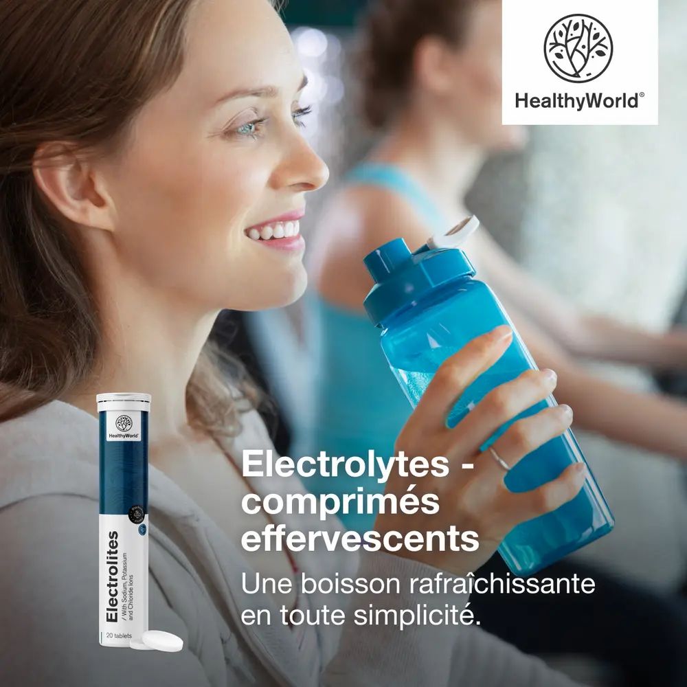 Femme buvant d'une gourde bleue après le sport, à côté un tube de comprimés effervescents d'électrolytes.