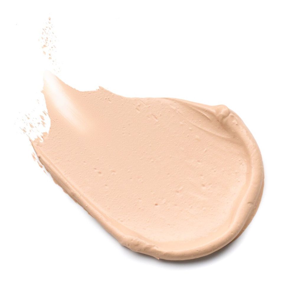Licht, crèmekleurig foundationveeg op witte achtergrond. De textuur is glad en romig.