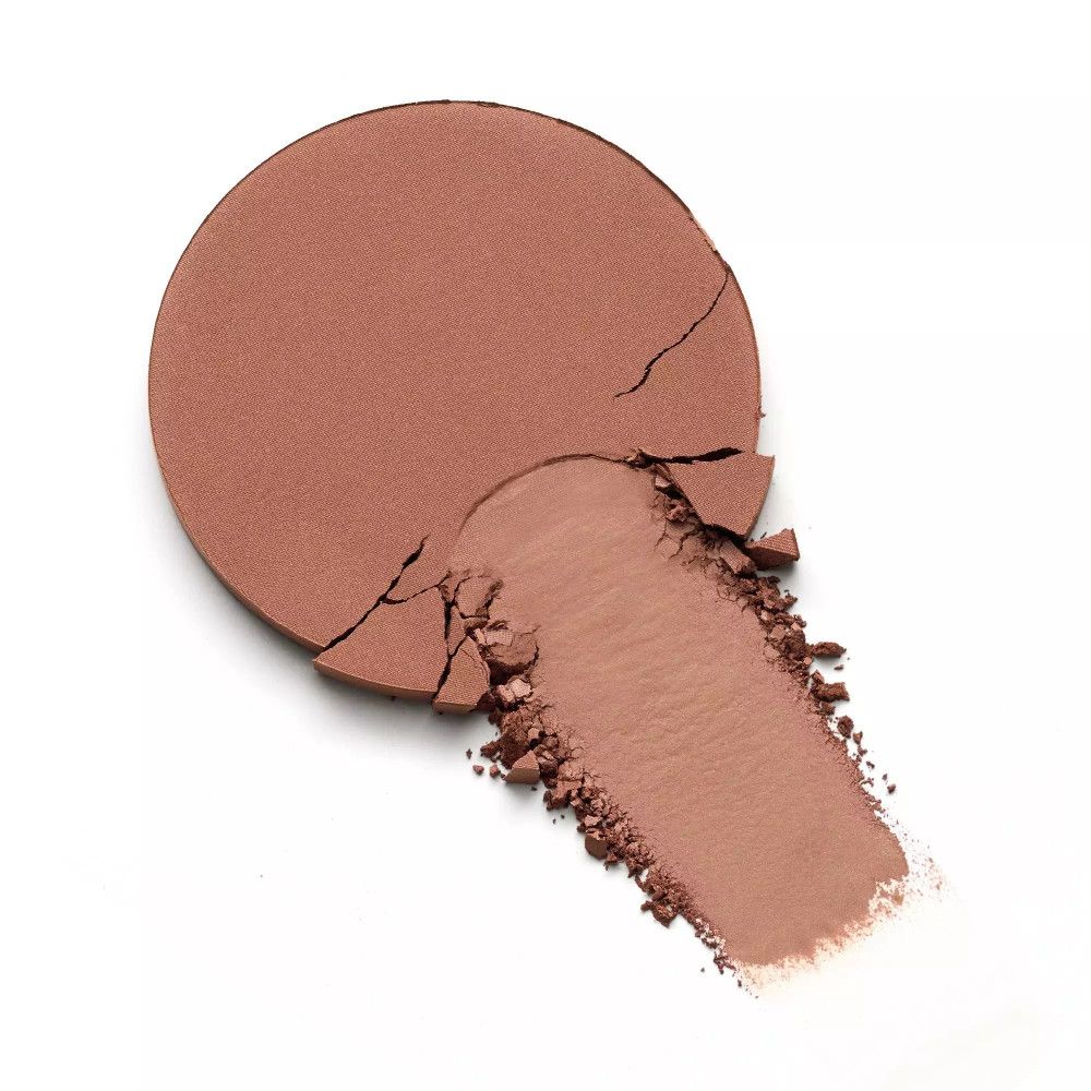 Ronde, gebroken bronzerpoeder met een veeg. De kleur is lichtbruin.
