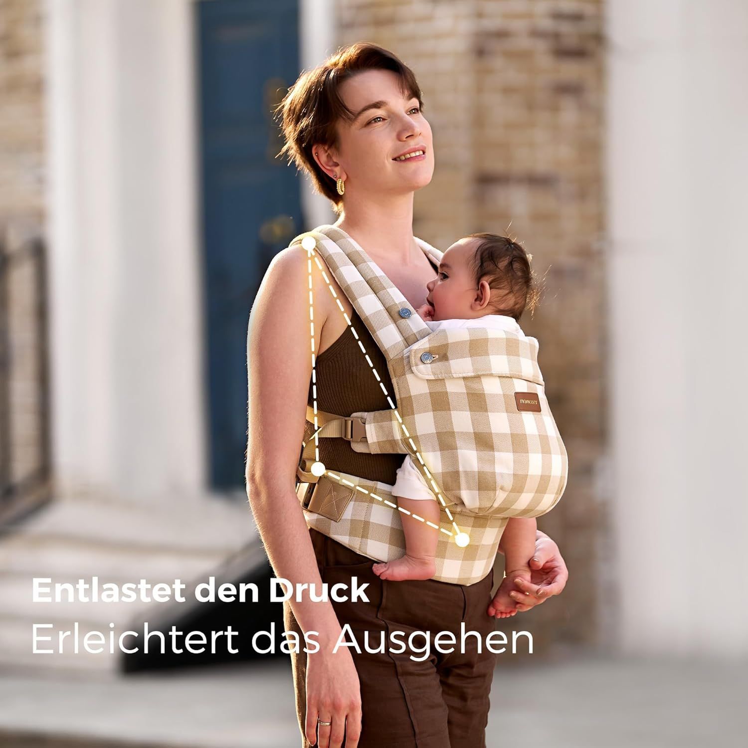 Vrouw met baby in babydrager met leisteen-ruitpatroon, wandelend. Tekst: Verlicht de druk.