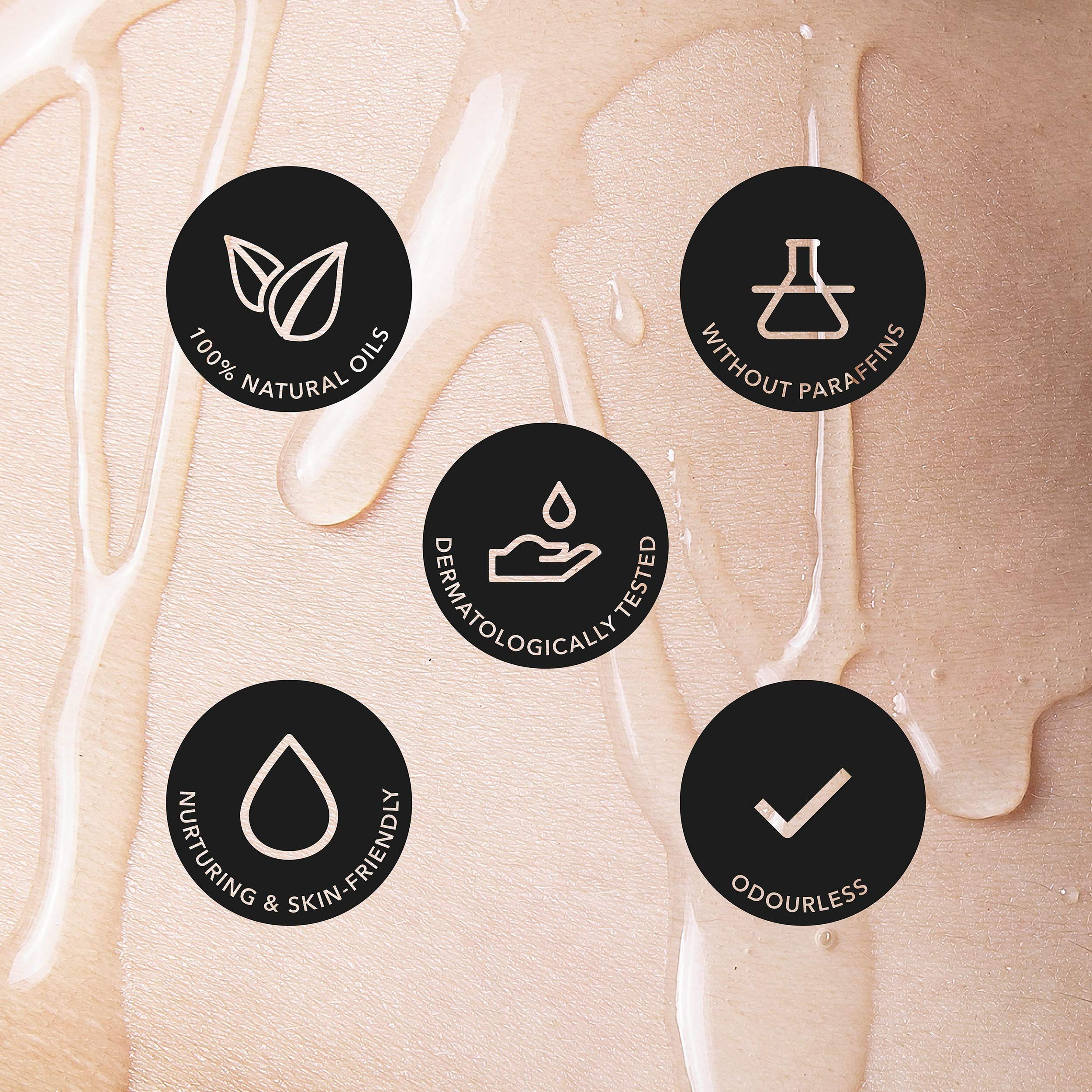 Fles Loovara Happy Hand massageolie met rood label en witte letters, omringd door oliespatten.
