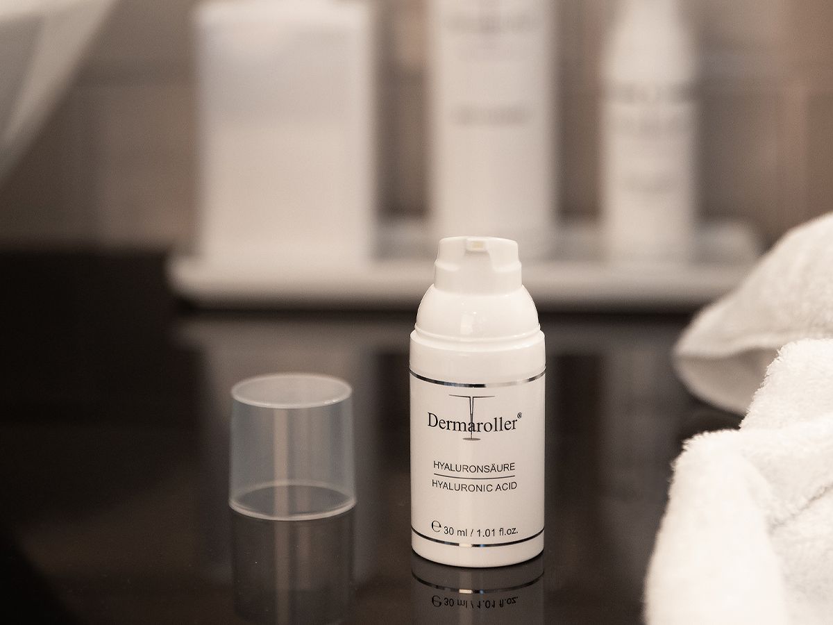 Witte dispenserfles met hyaluronzuur, dop ernaast.
