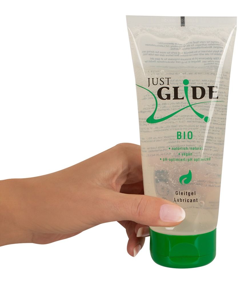 Tube avec bouchon vert. Nom du produit : Just Glide *Bio*. Main tenant le tube.