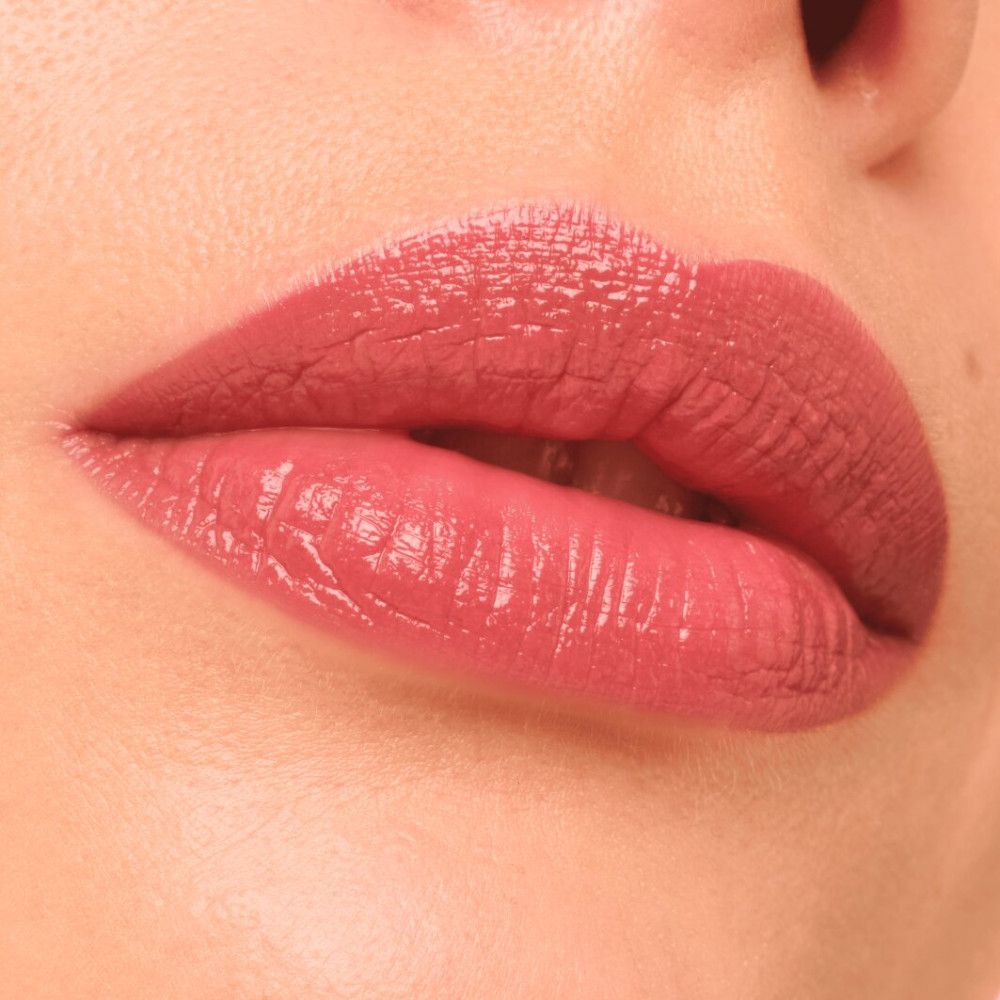Close-up van lippen met roze gloss. De lippen zijn licht geopend en glanzend.