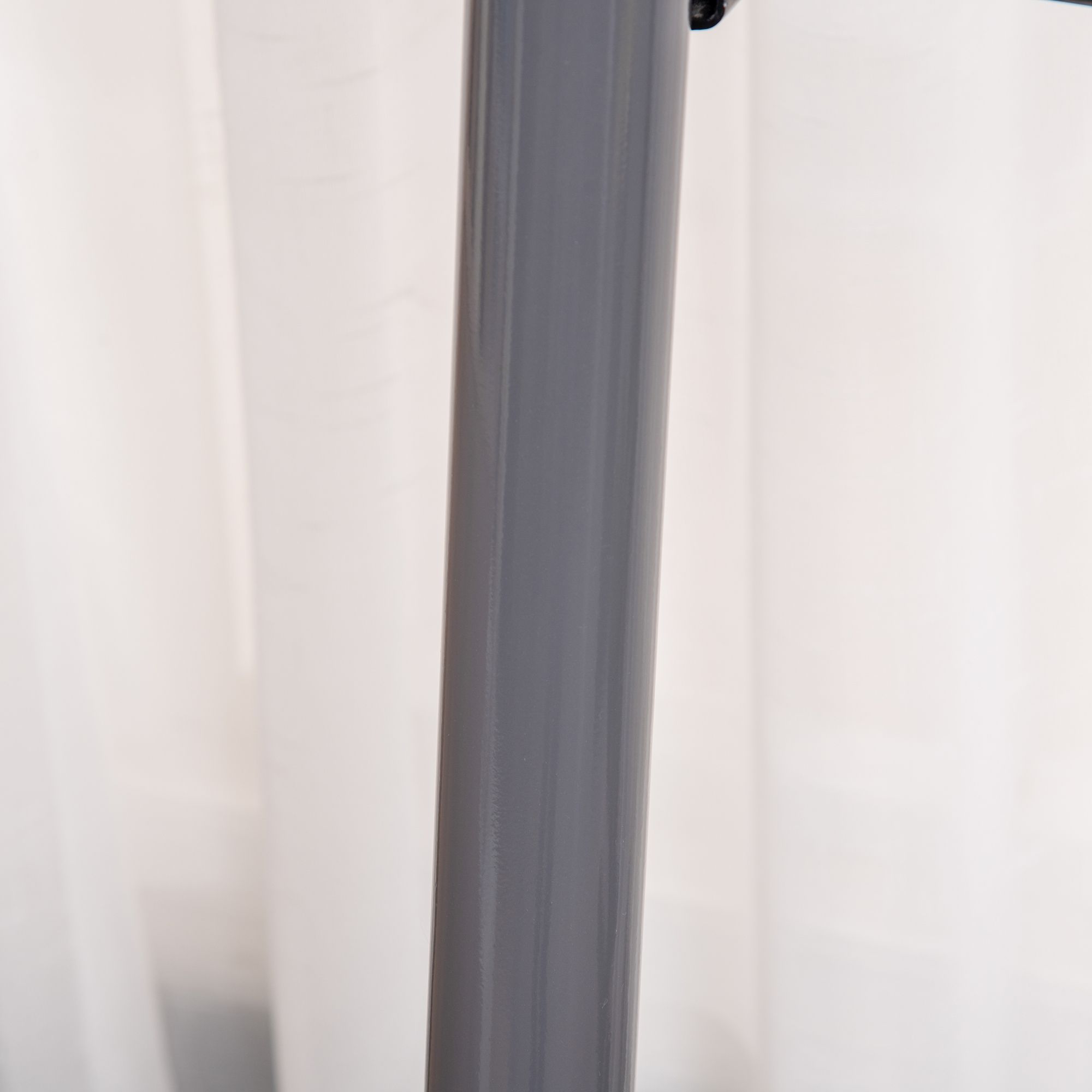 Close-up van een grijze stepperpaal. Glad oppervlak, geen andere details zichtbaar.