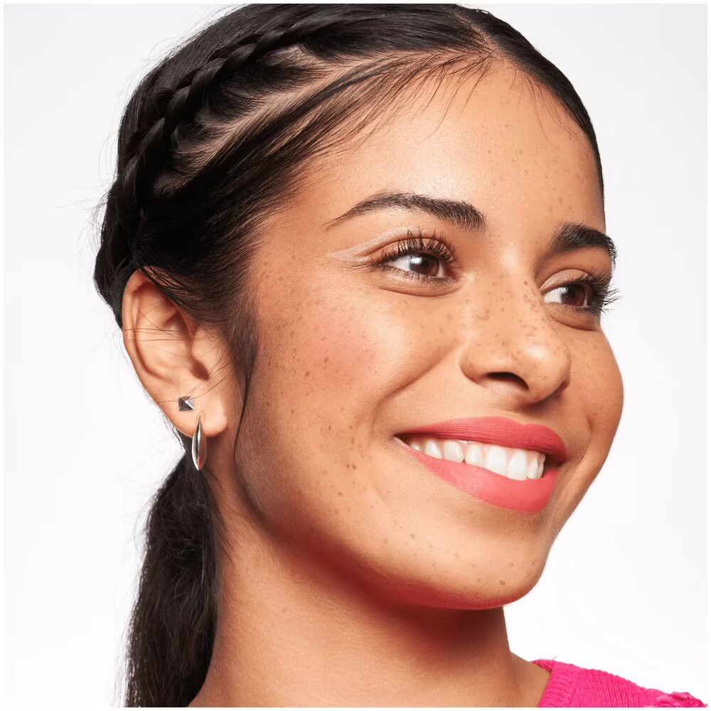 Portret van een vrouw met vlechten. Ze draagt blush op wangen en lippen. Natuurlijke make-up.