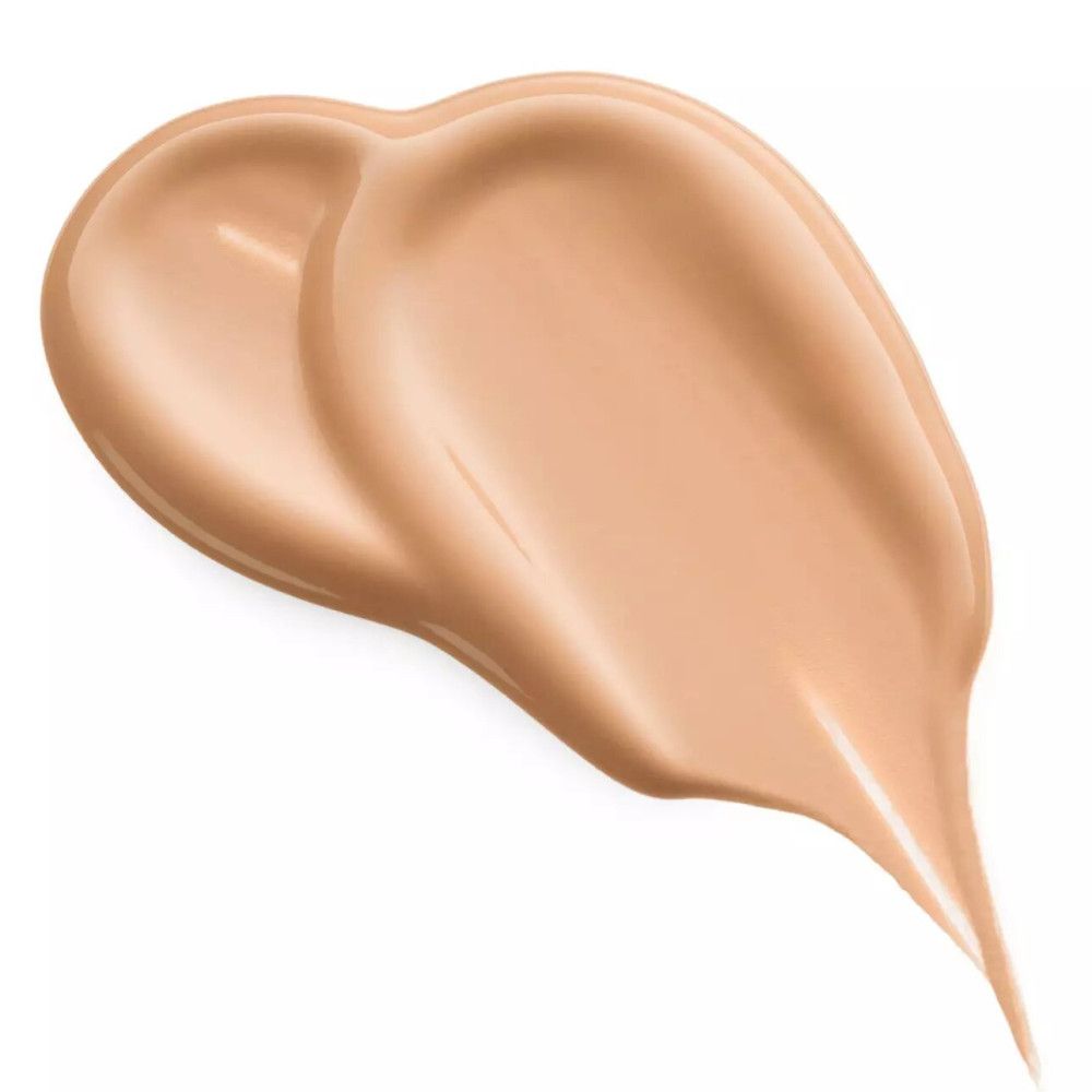 Échantillon de correcteur étalé. Teinte brun clair. Texture lisse. Sur fond clair.