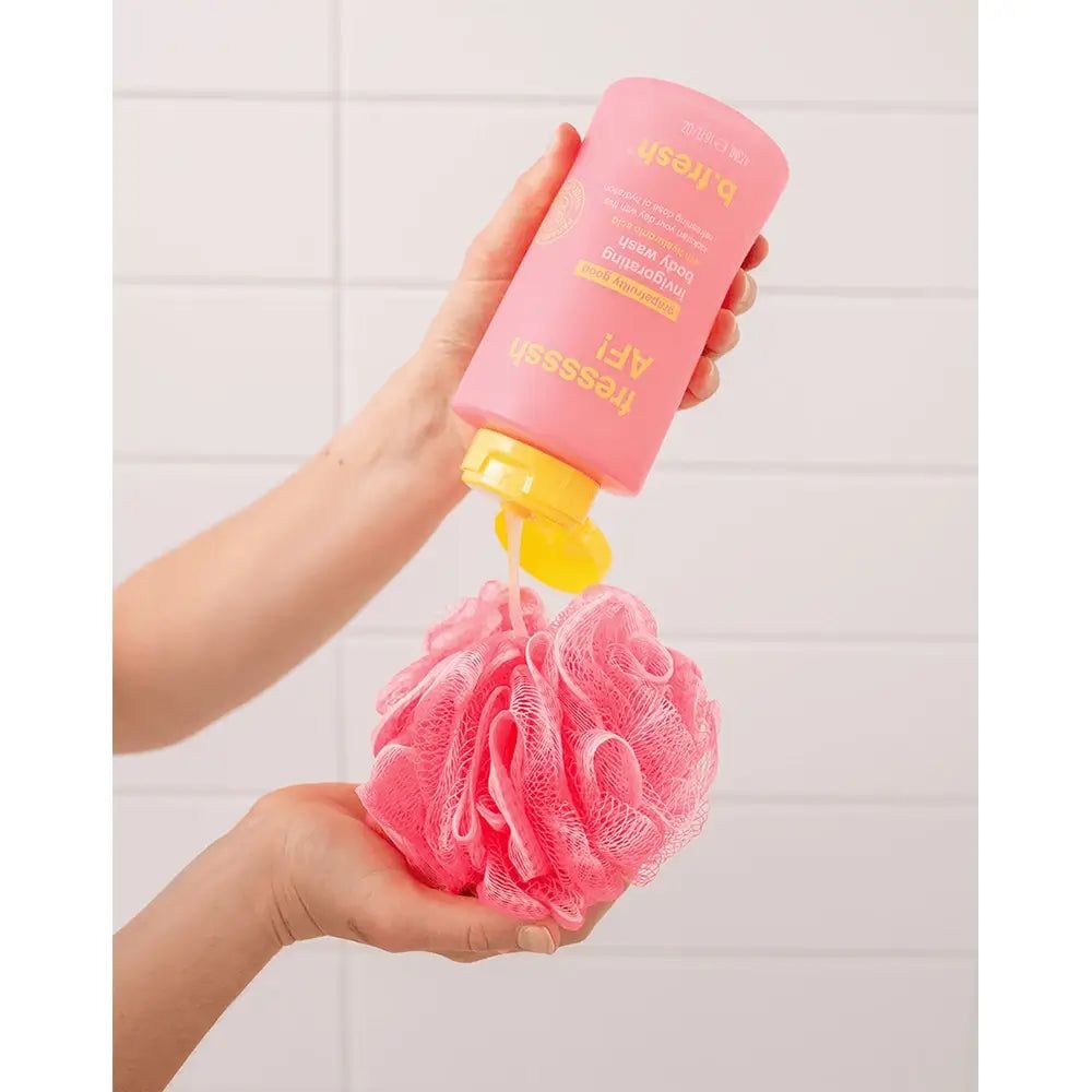 Roze douchegel wordt op een roze badspons gegoten. Gele dop. Opschrift: b.fresh Fressssh AF!