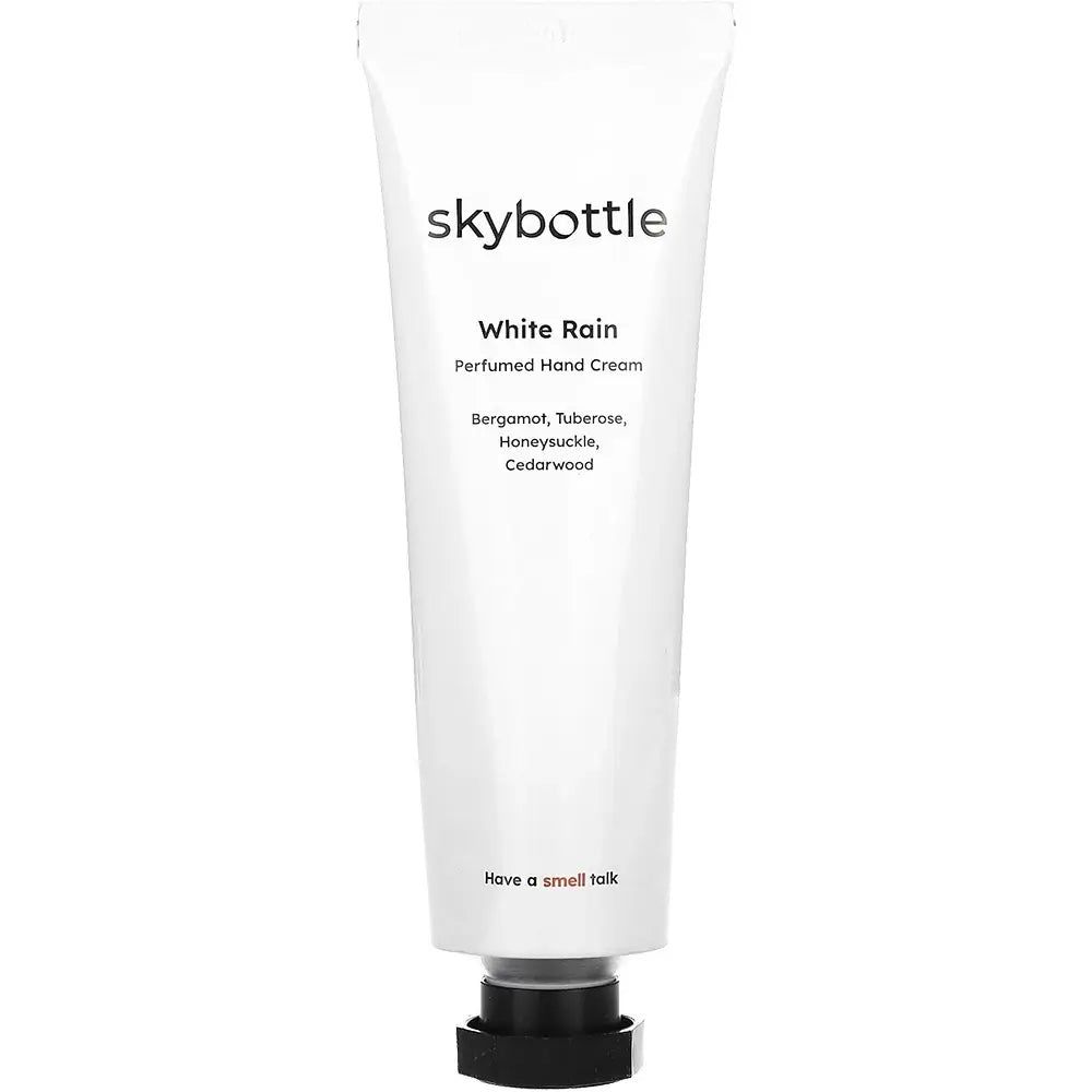 Tube de crème pour les mains blanche. Inscription : skybottle, White Rain. Ingrédients : Bergamote, Tubéreuse, Chèvrefeuille, Bois de cèdre.