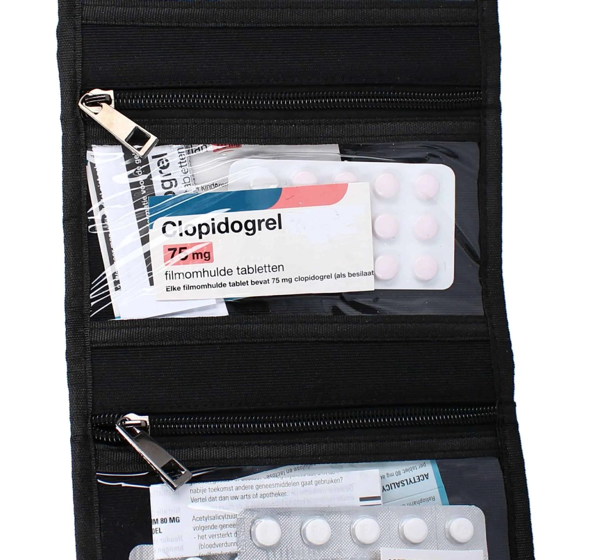 Gros plan d'un étui à médicaments noir ouvert, avec des pilules dans des compartiments transparents.