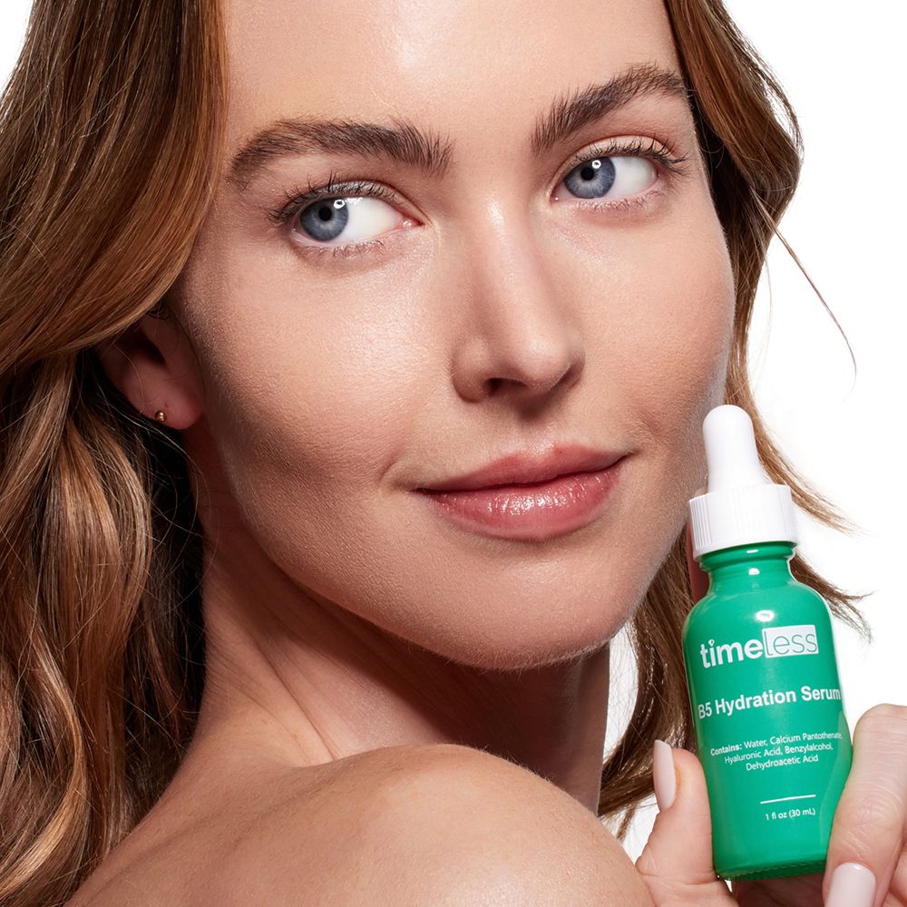 Vrouw houdt een groene fles vast. Opschrift: timeless, B5 Hydration Serum. Gezicht in focus. Huidverzorgingsproduct.