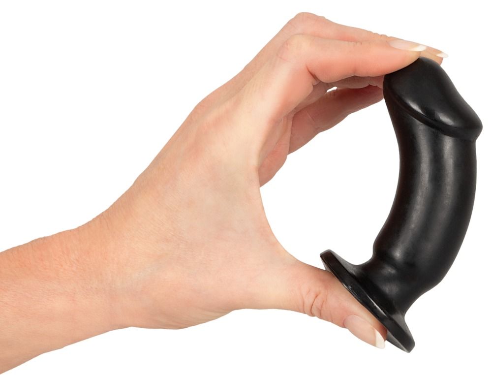 Une main tient un plug anal noir. La forme est cylindrique avec une pointe arrondie et une large base.