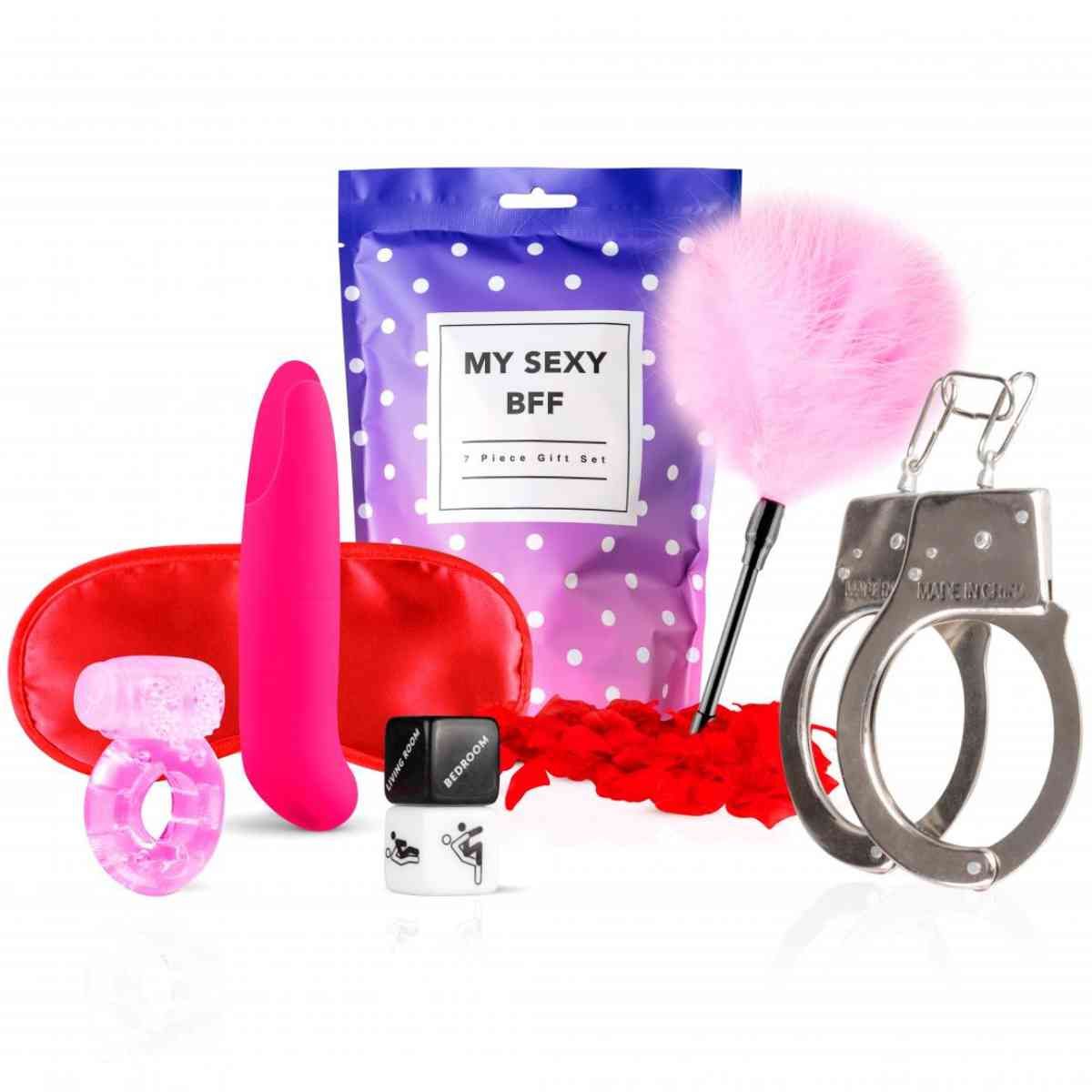 Set met oogmasker, ring, vibrator, plumeau, handboeien, glijmiddel en cadeauzakje. Roze, rode en zilveren elementen.