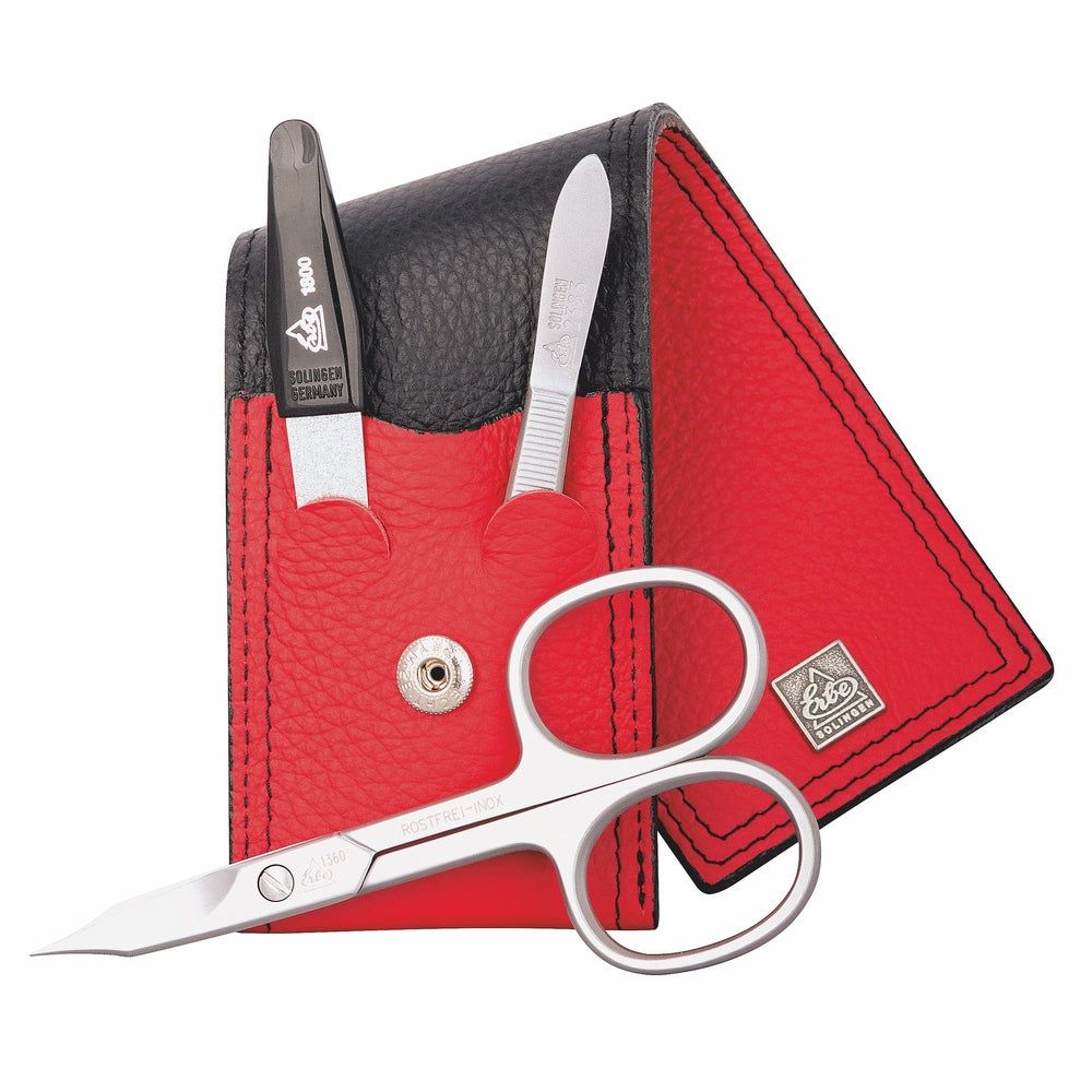 Set de manucure avec ciseaux, repousse-cuticules et lime à ongles dans un étui en cuir rouge avec insert noir.