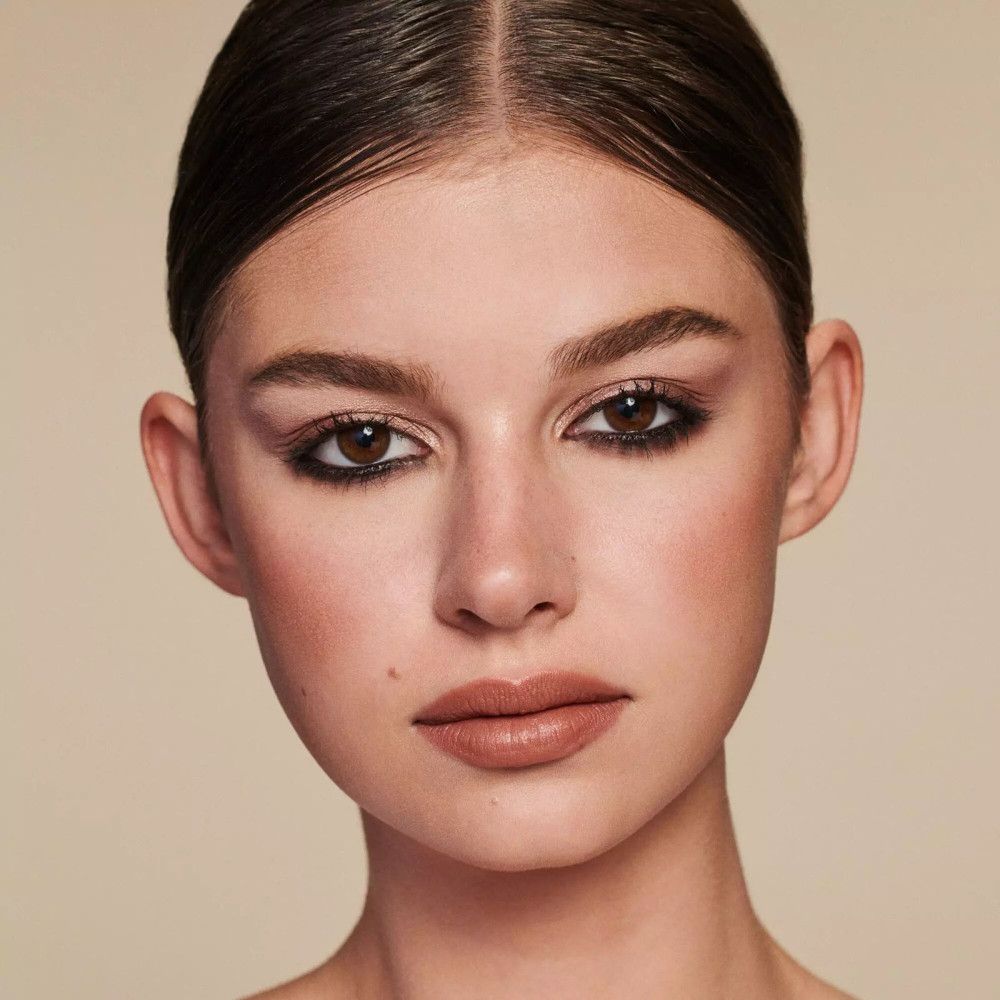 Portrait d'une femme avec sourcils et lèvres maquillés. Teint clair.