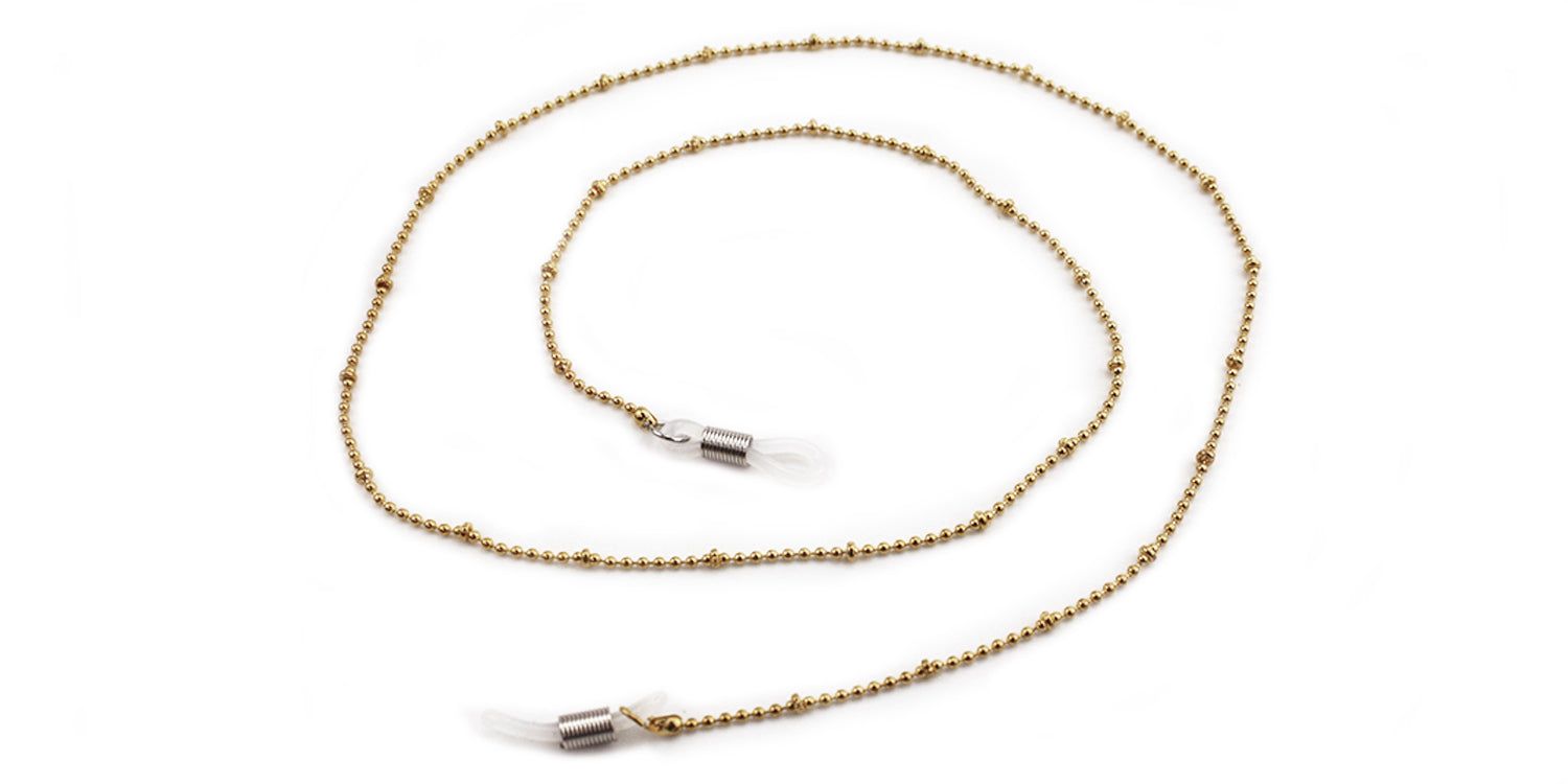 Gouden brillenkoord met bolletjes. Transparante siliconen lussen aan de uiteinden voor bevestiging aan de pootjes.