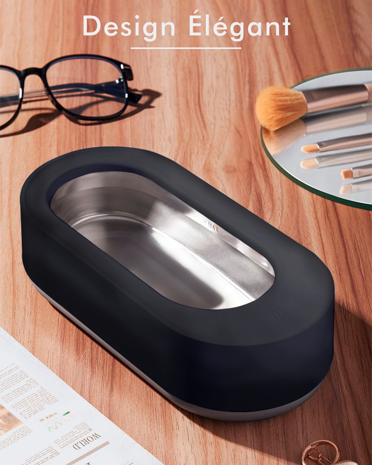 Appareil de nettoyage à ultrasons noir. Forme ovale. Sur une surface en bois. Lunettes, pinceaux et miroir à côté.