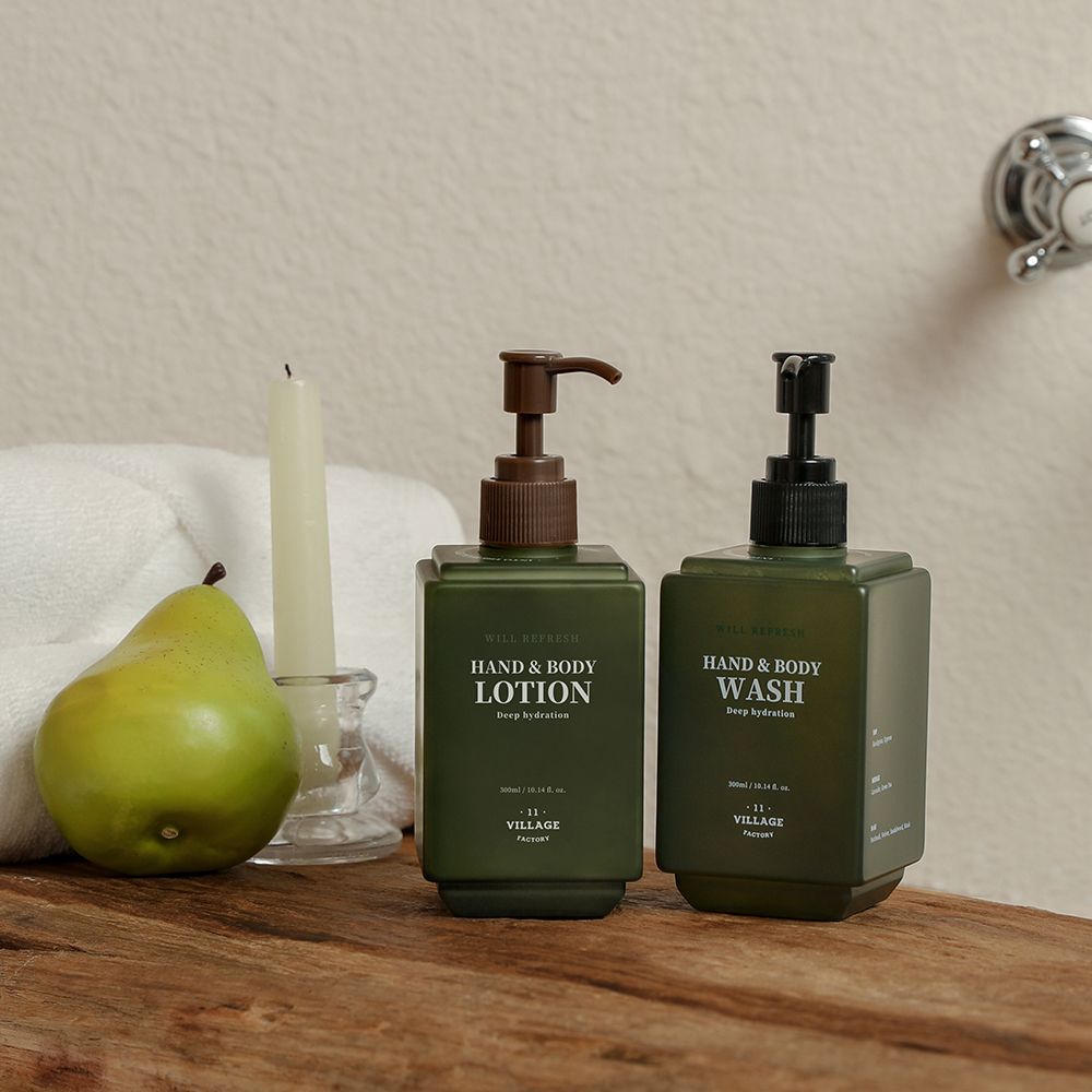 Twee groene flessen met pompen. Opschrift: Hand & Body Lotion en Hand & Body Wash. Merk: VILLAGE 11 FACTORY.