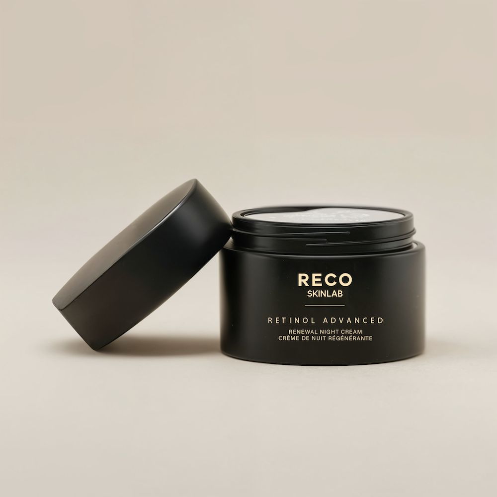 Zwarte pot met open deksel. Opschrift: RECO SKINLAB, RETINOL ADVANCED, Renewal Night Cream. Het deksel ligt ernaast.
