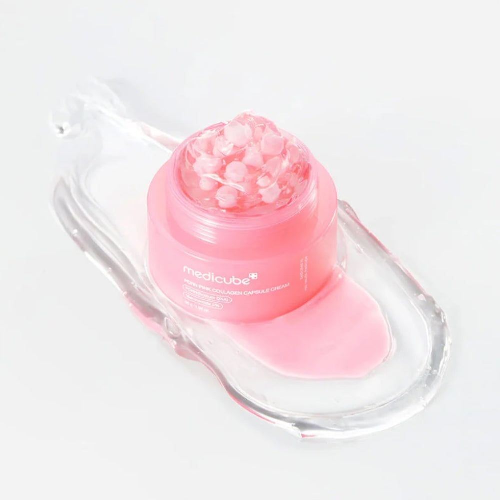 Medicube PDRN Pink Collagen Capsule Cream dans un pot rose sur un plateau transparent.