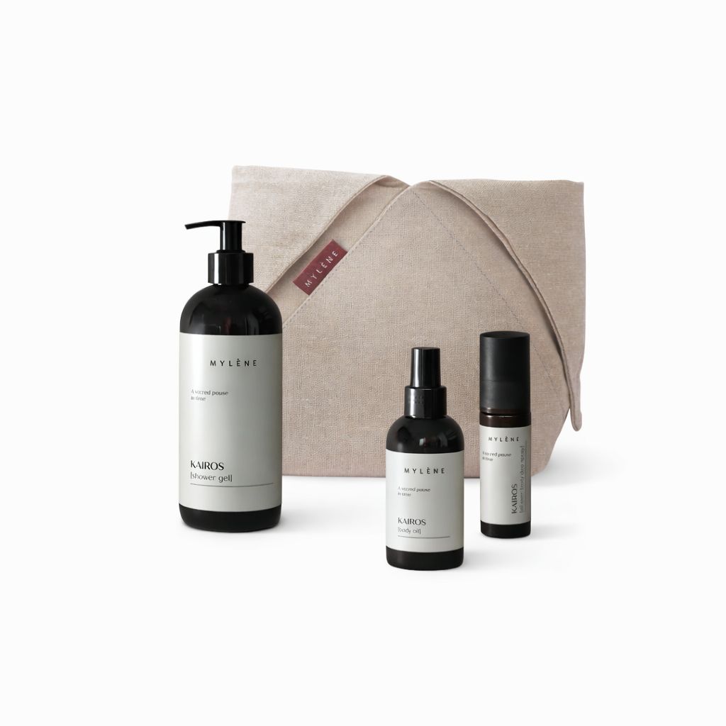Ensemble de gel douche, huile, roll-on et sac. Flacons noirs avec étiquettes blanches. Sac beige avec étiquette rouge.
