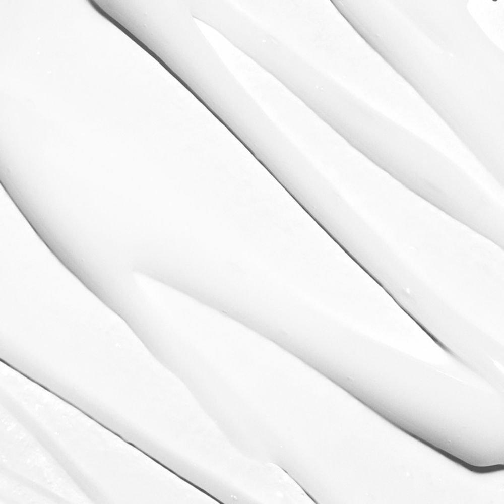 Close-up van witte crème. De crème is in golvende lijnen aangebracht.