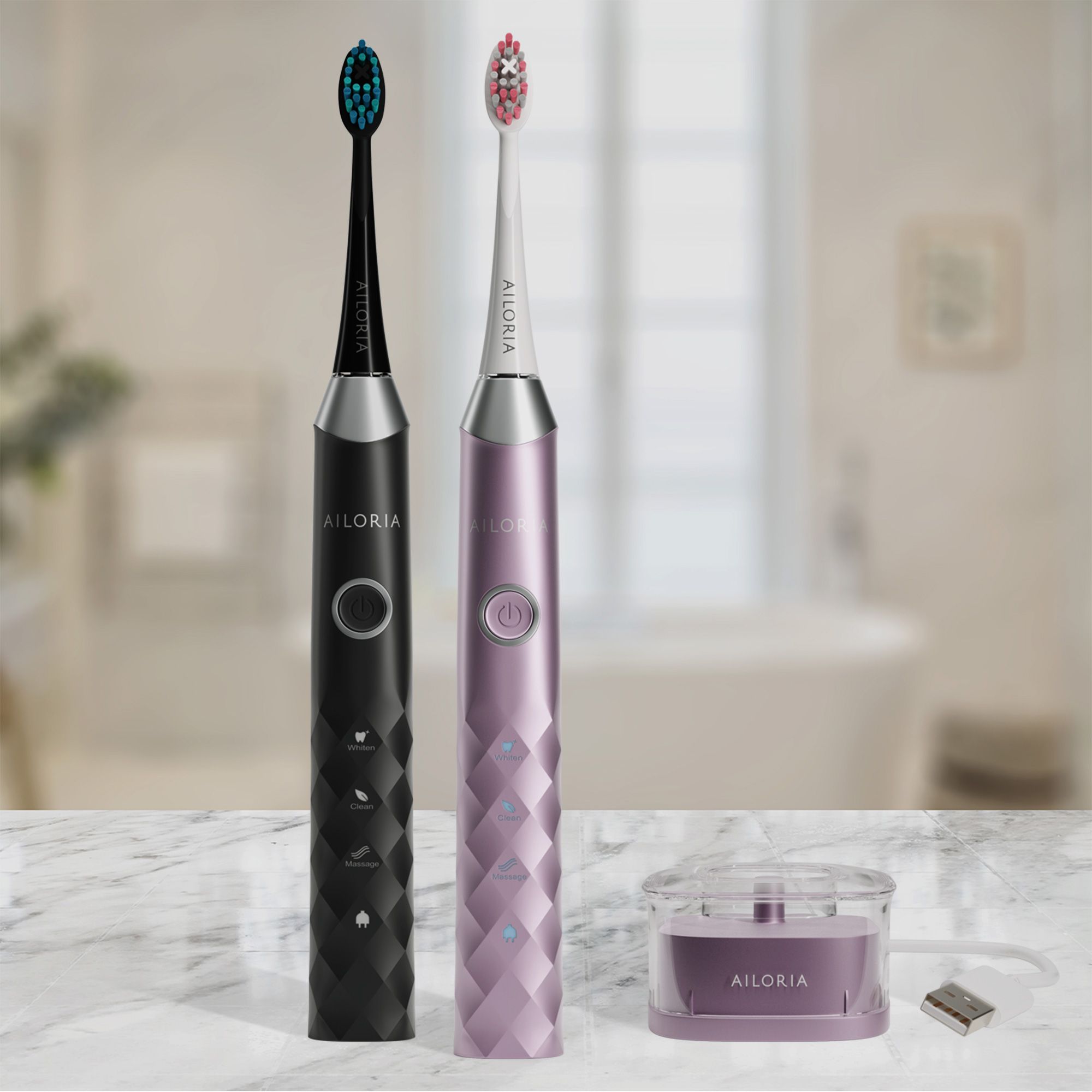 Deux brosses à dents soniques AILORIA, noires et roses, avec station de charge. Inscription AILORIA.