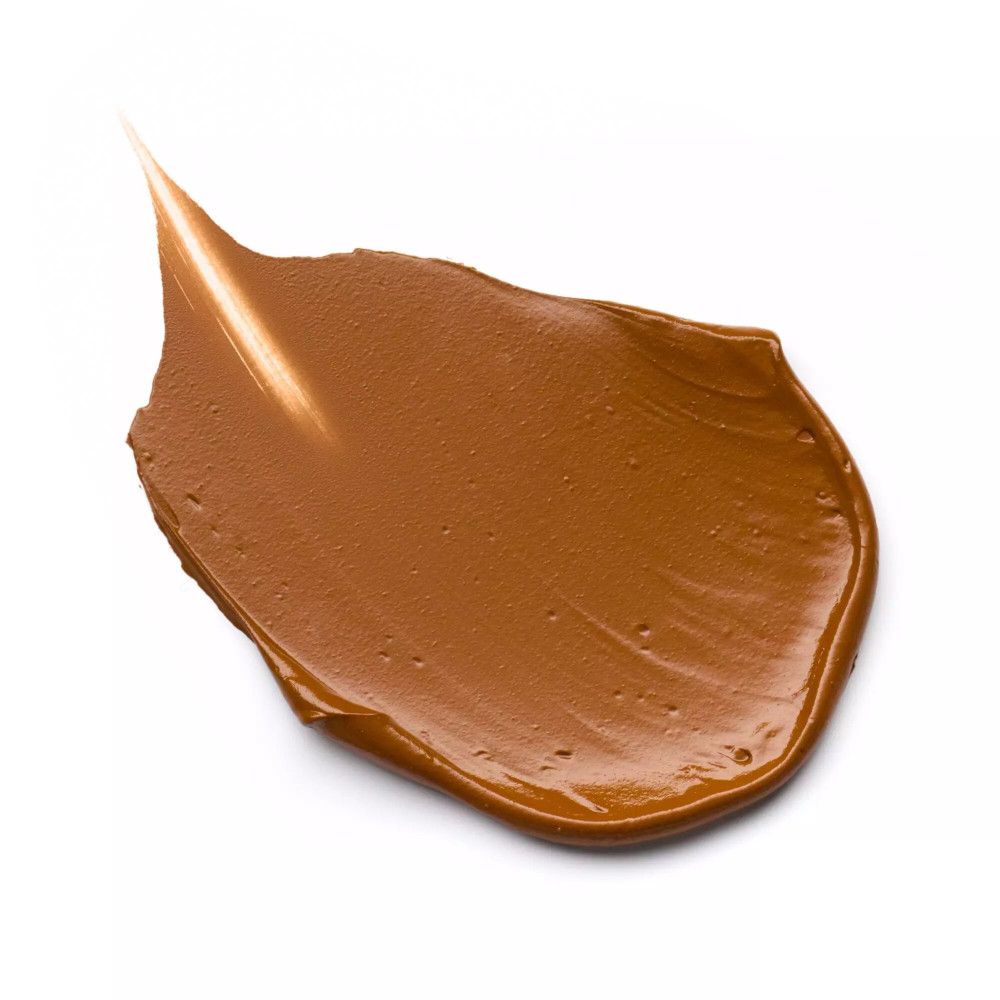 Bruine foundationvlek op witte achtergrond. Textuur met puntig uiteinde, tint.