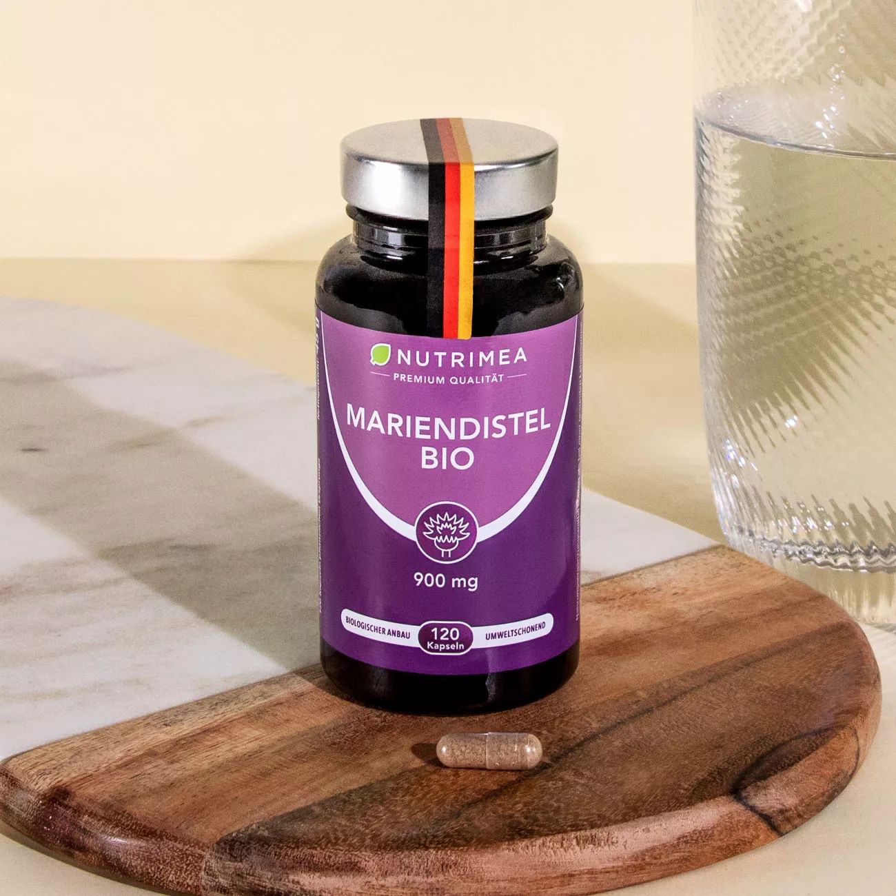 Flacon Chardon-Marie BIO sur planche de bois. 1 gélule à côté. Logo : Nutrimea. 900 mg.