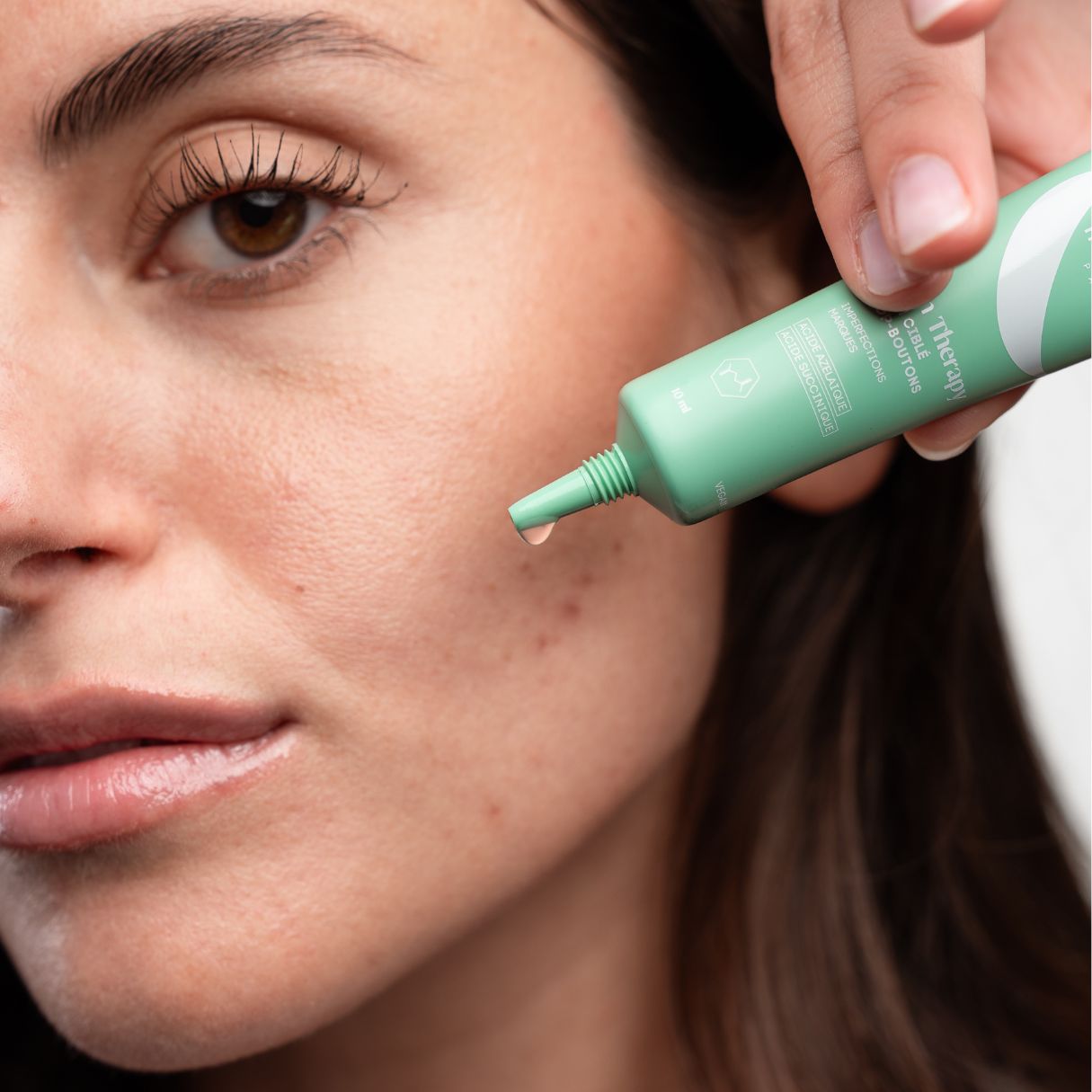 Tube verte, goutte. Application sur la peau. Texte: Skin Therapy, Cure & Routine.