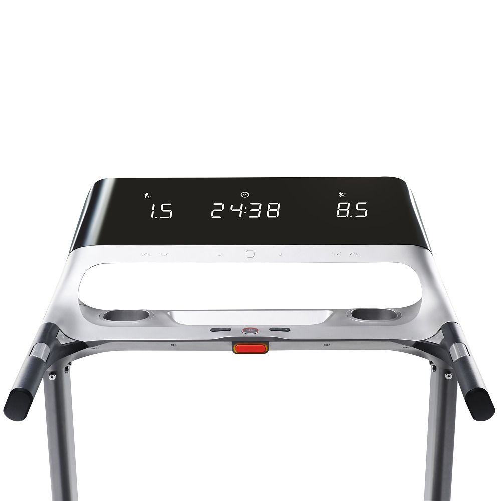 Gros plan sur la console d'un tapis de course. Affichage numérique avec valeurs. Cadre gris. Poignées noires.