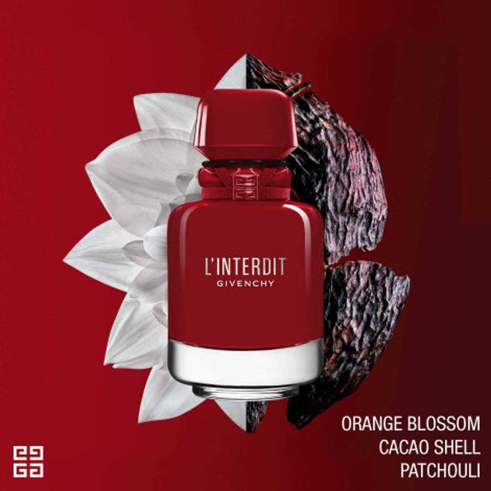 Flacon rouge Givenchy L'Interdit Rouge Ultime. Flacon avec bague argentée et bouchon rouge. Fond avec fleurs et coque de cacao.