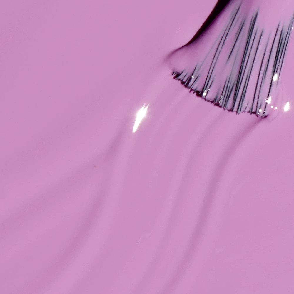 Pinceau trempé dans du vernis à ongles lilas clair. Le pinceau révèle la texture du vernis.