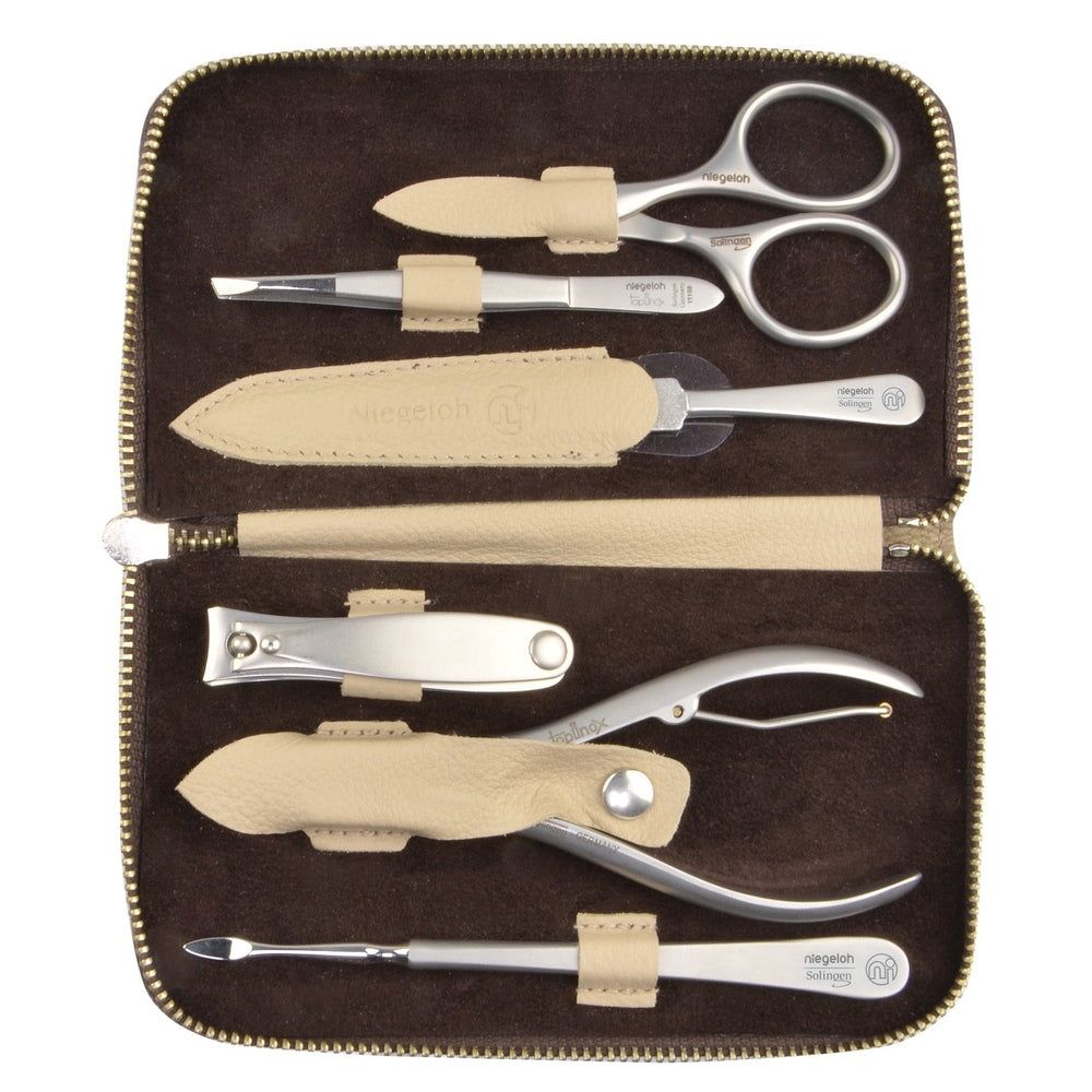 Open bruine cosmetische etui met manicuregereedschap. Bevat schaar, pincet, nagelvijl, nagelknipper en meer.