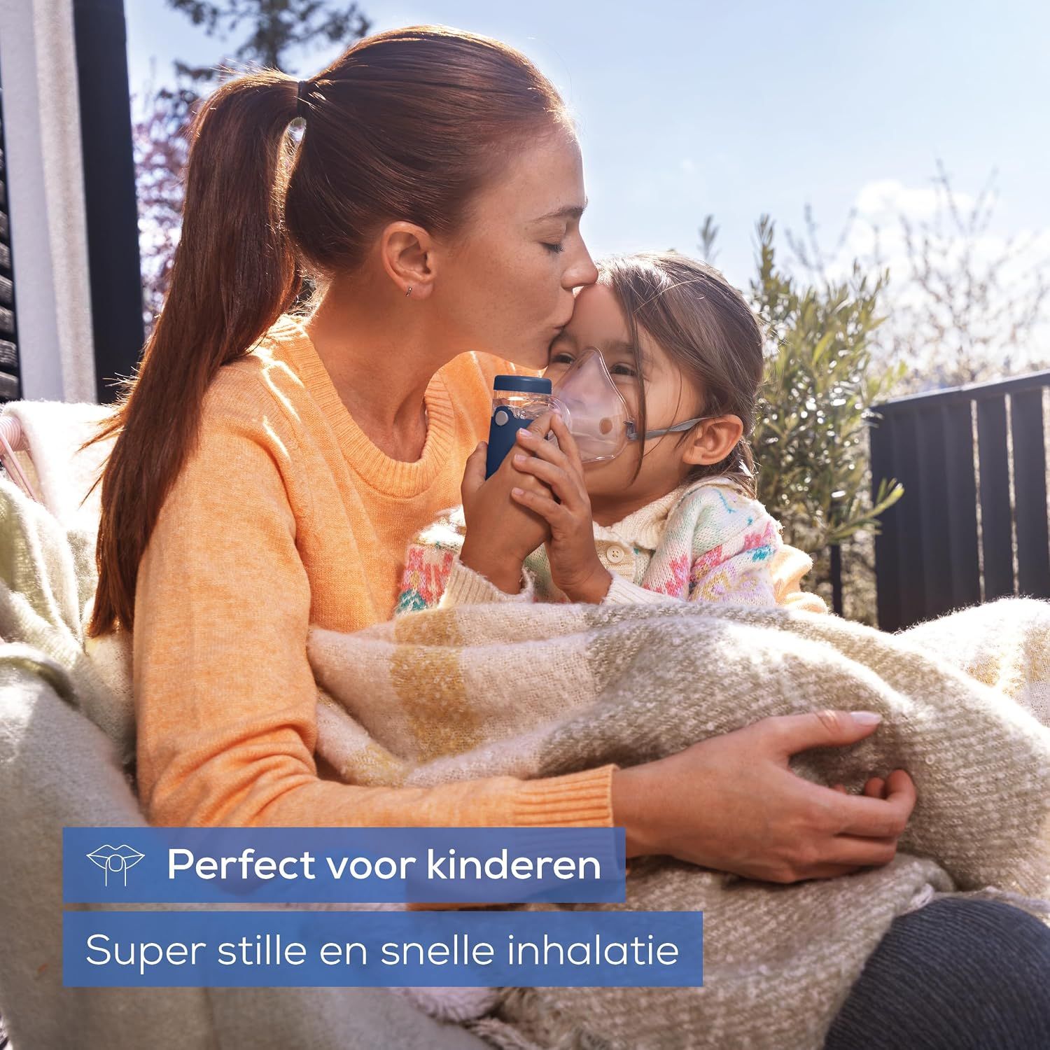 Een blauwe vernevelaar met masker wordt door een vrouw bij een kind gehouden.
